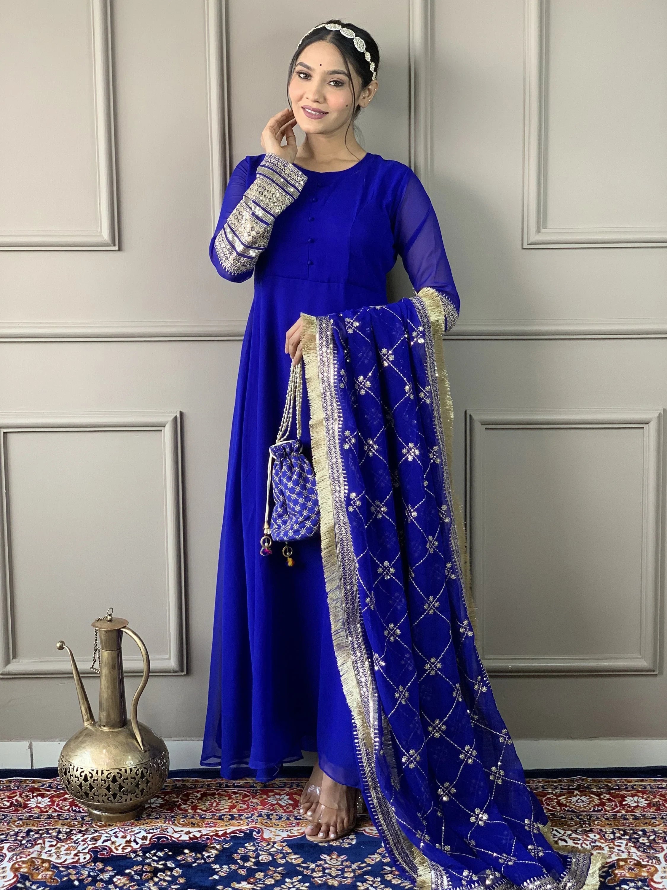 Woman in royal blue Indian Anarkali suit with embroidered dupatta and traditional accessories