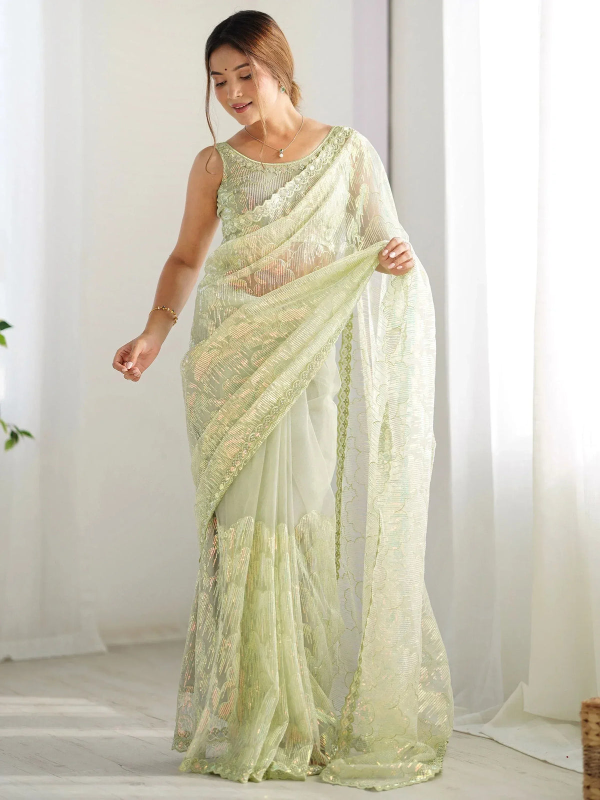 Light green embroidered saree with lace detailing, perfect for Indian ethnic wear occasions