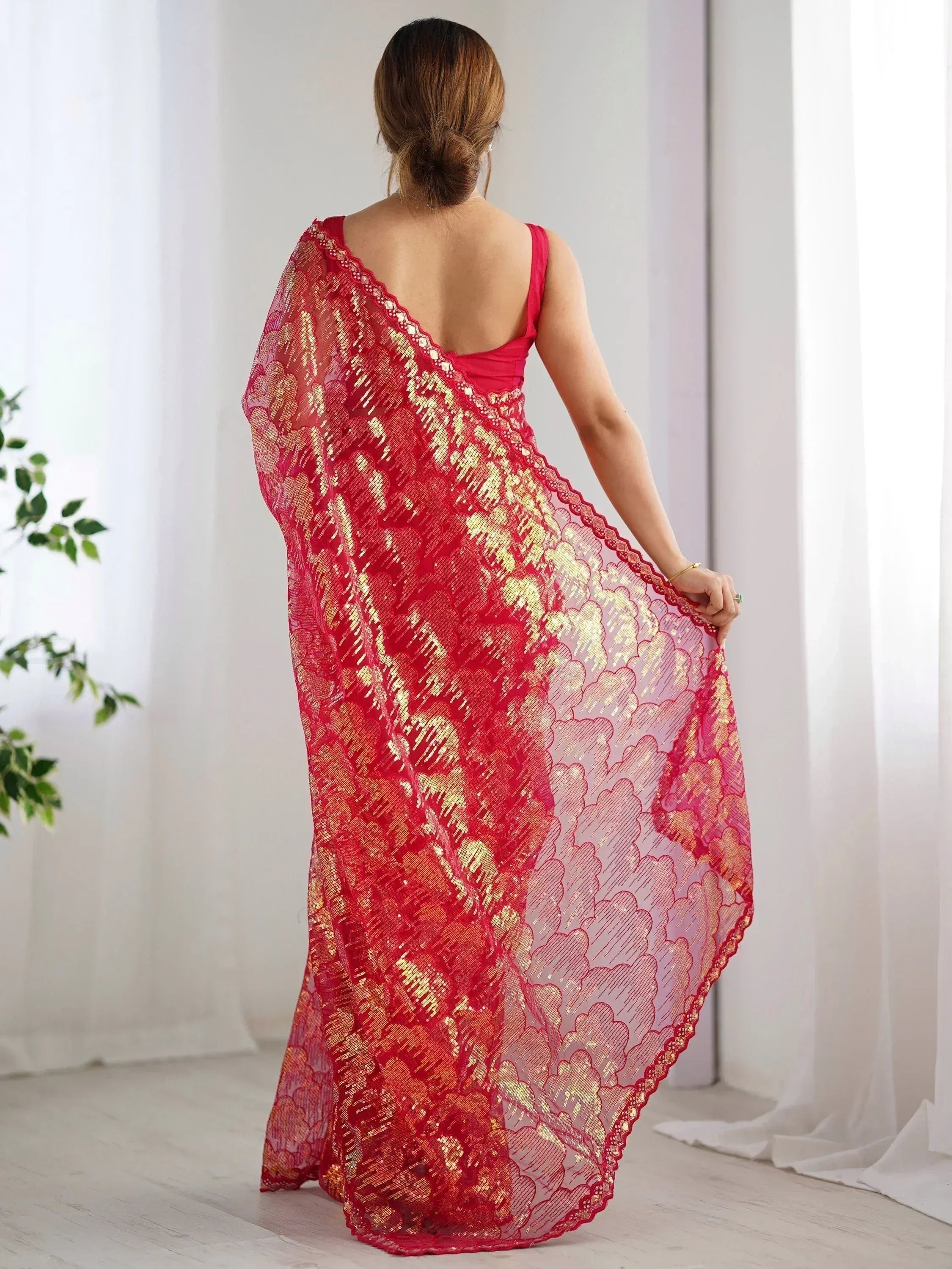 Red and gold embroidered saree with lace border, styled with backless blouse for ethnic wear
