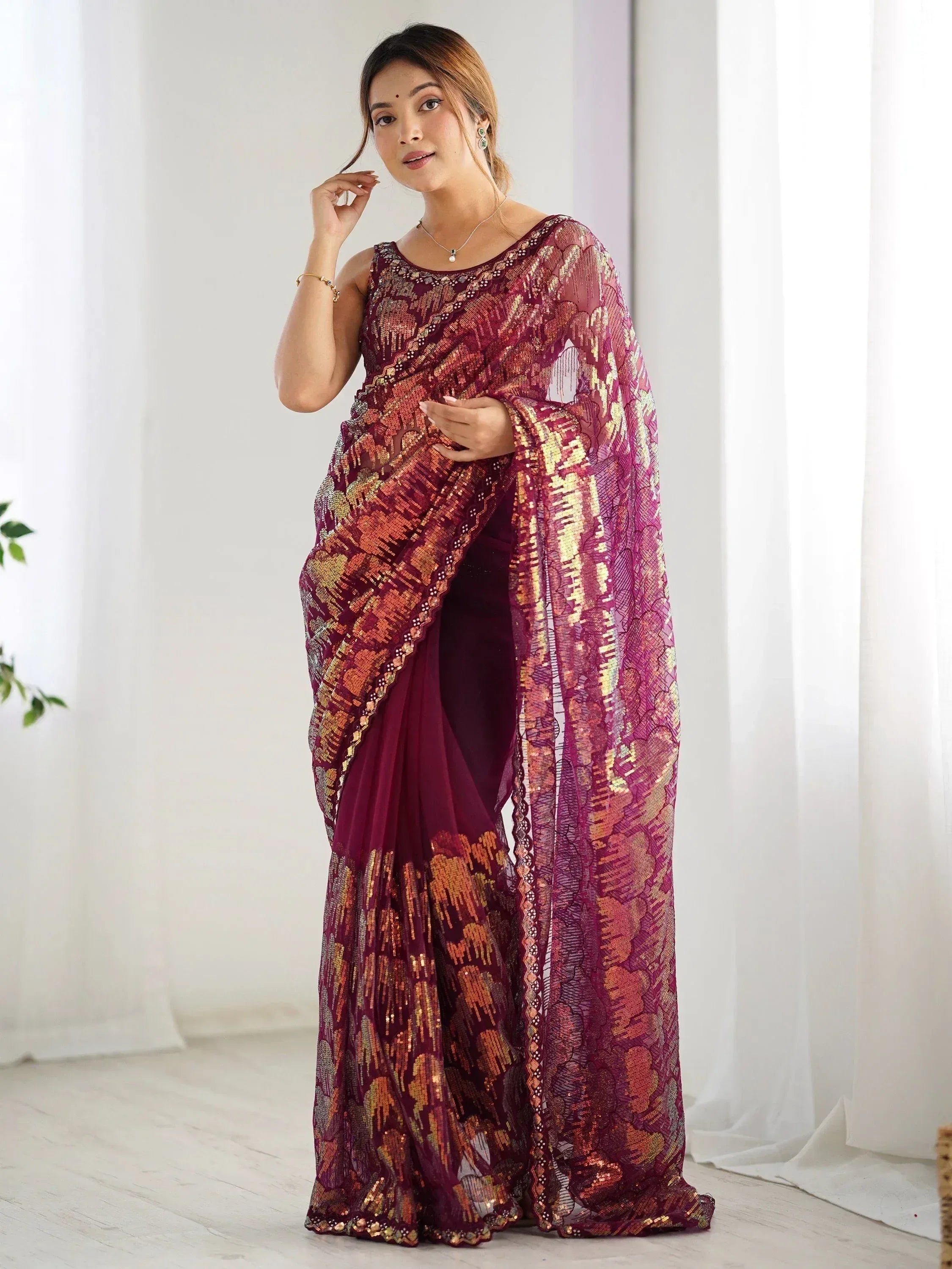 Woman in maroon embroidered saree with gold sequin work, stylish Indian ethnic wear for festive occasions