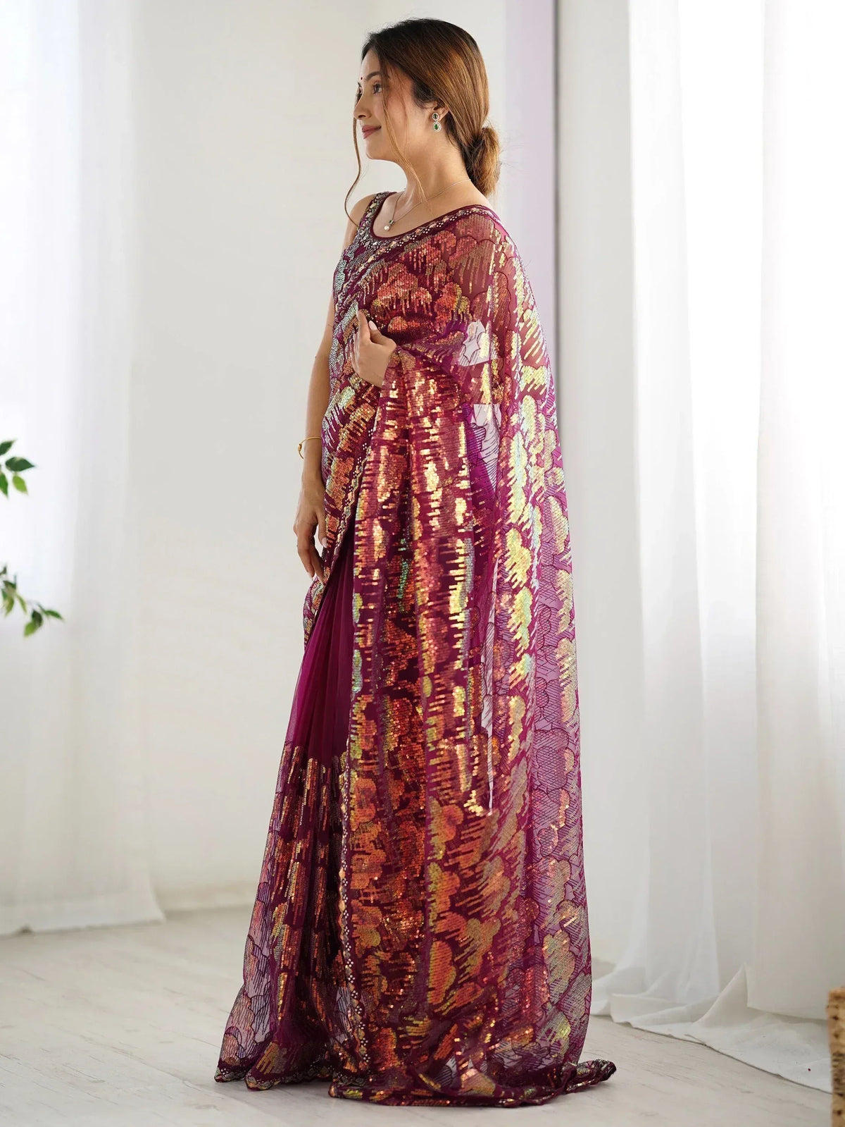 Woman in maroon sequin saree with gold floral pattern, elegant Indian ethnic wear for festive occasions