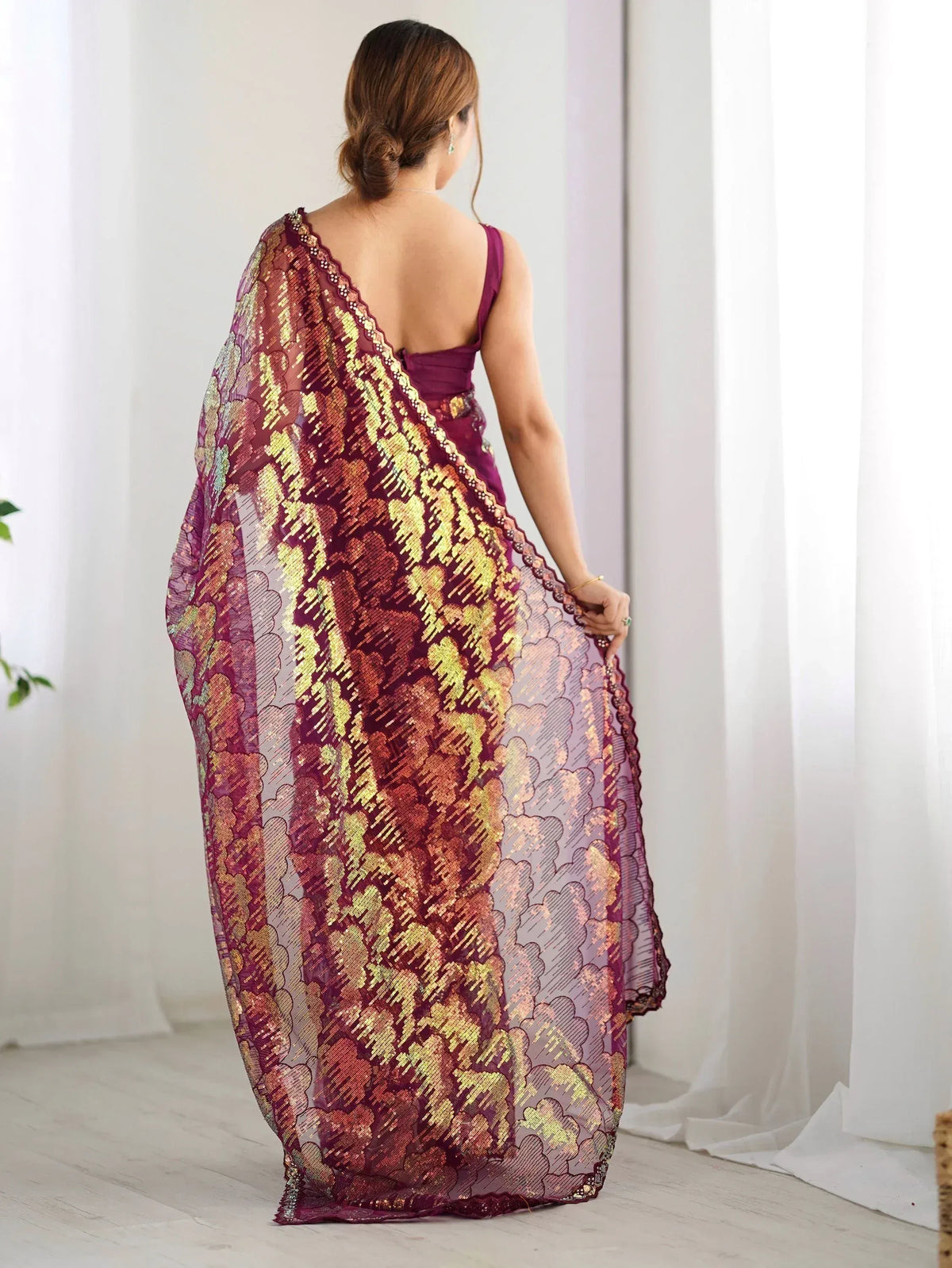 Woman in elegant maroon and gold embroidered saree, showcasing designer ethnic wear for special occasions