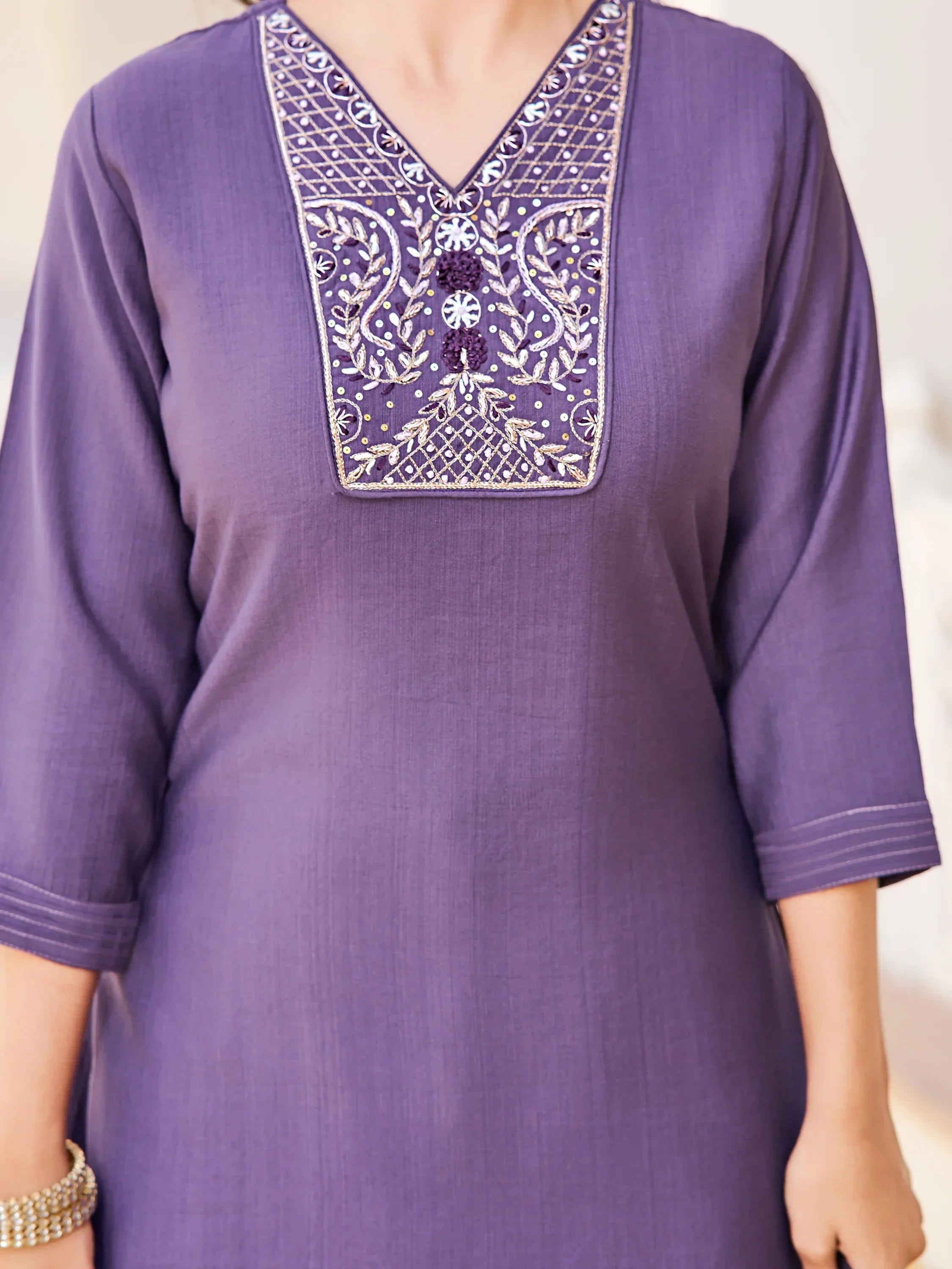 Purple kurti with intricate embroidery on the neckline and three-quarter sleeves