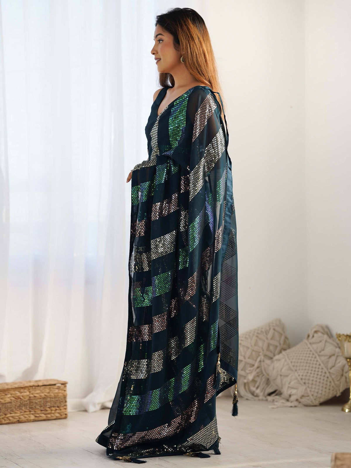 Elegant dark green ethnic gown with shimmering sequin patterns and tassels, perfect for festive occasions.