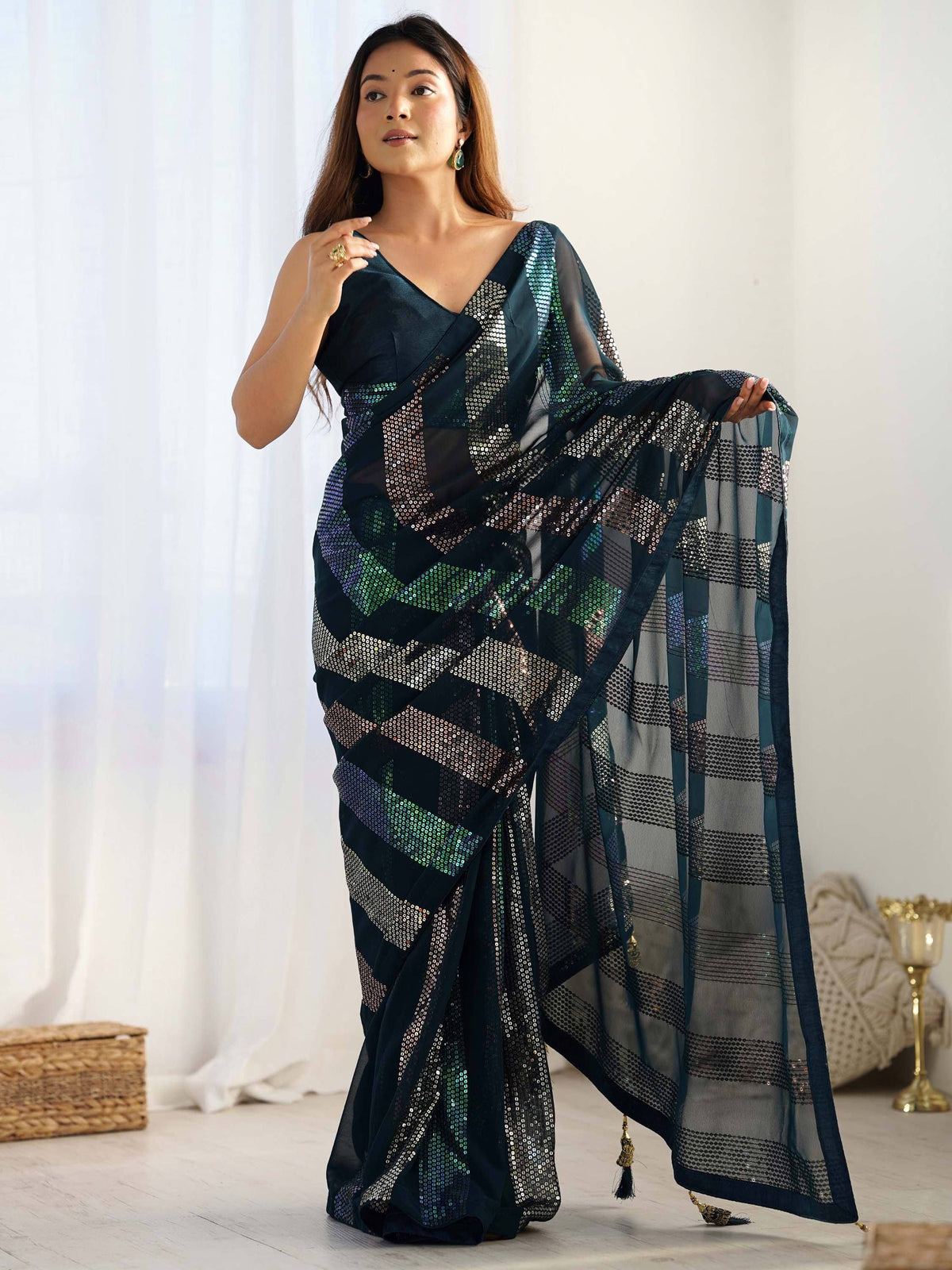 Woman in elegant dark green sequin saree with sheer pallu, perfect for Indian ethnic occasions.
