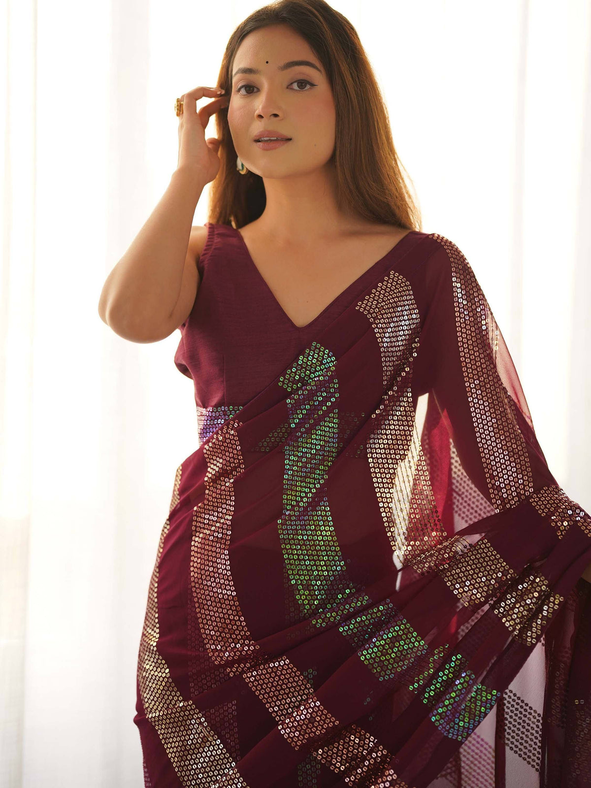 Woman in maroon ethnic saree with sequin detailing, perfect for Indian festive occasions