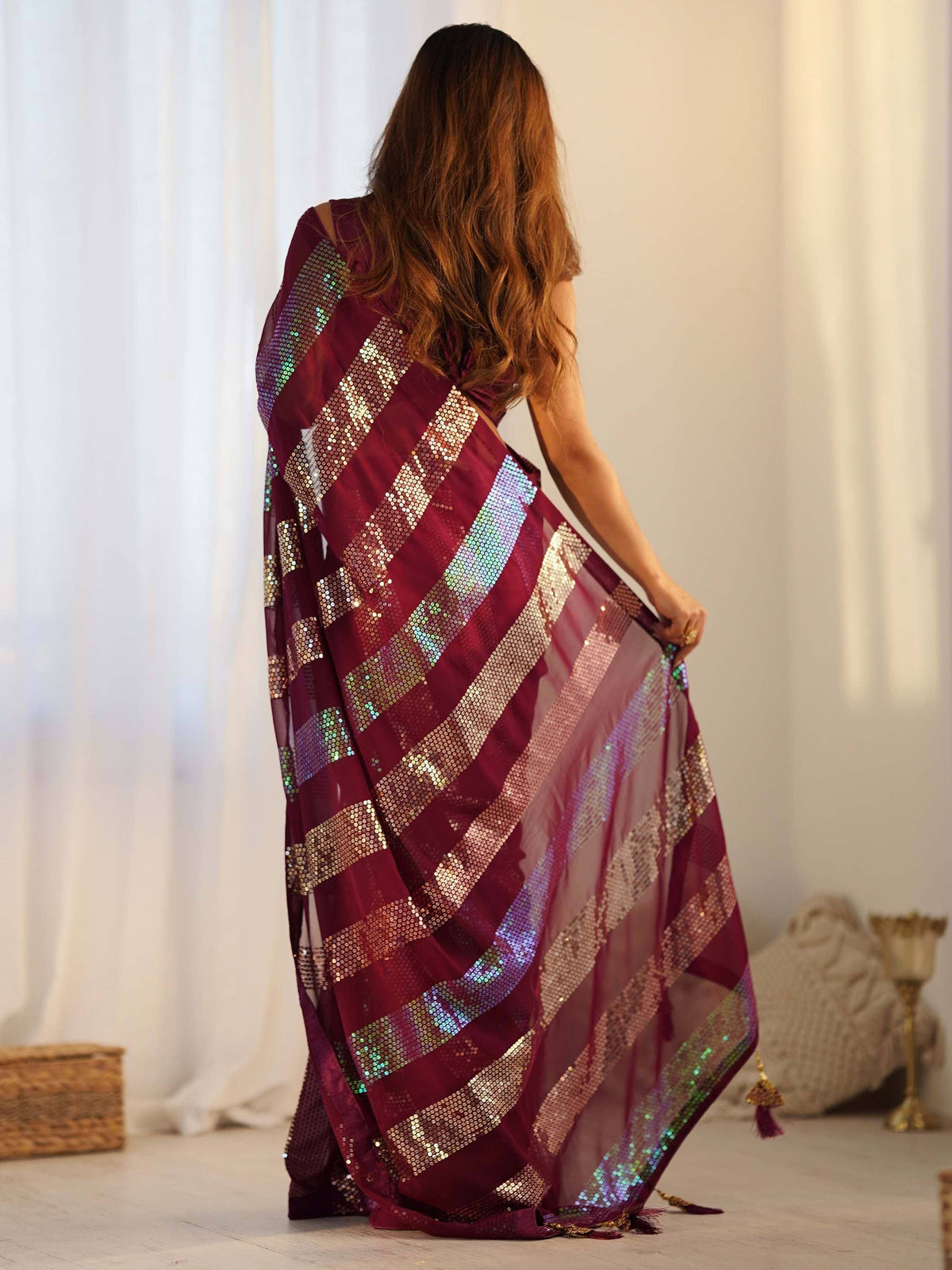 Woman in maroon sequin saree with iridescent stripes, ethnic Indian wear for festive occasions
