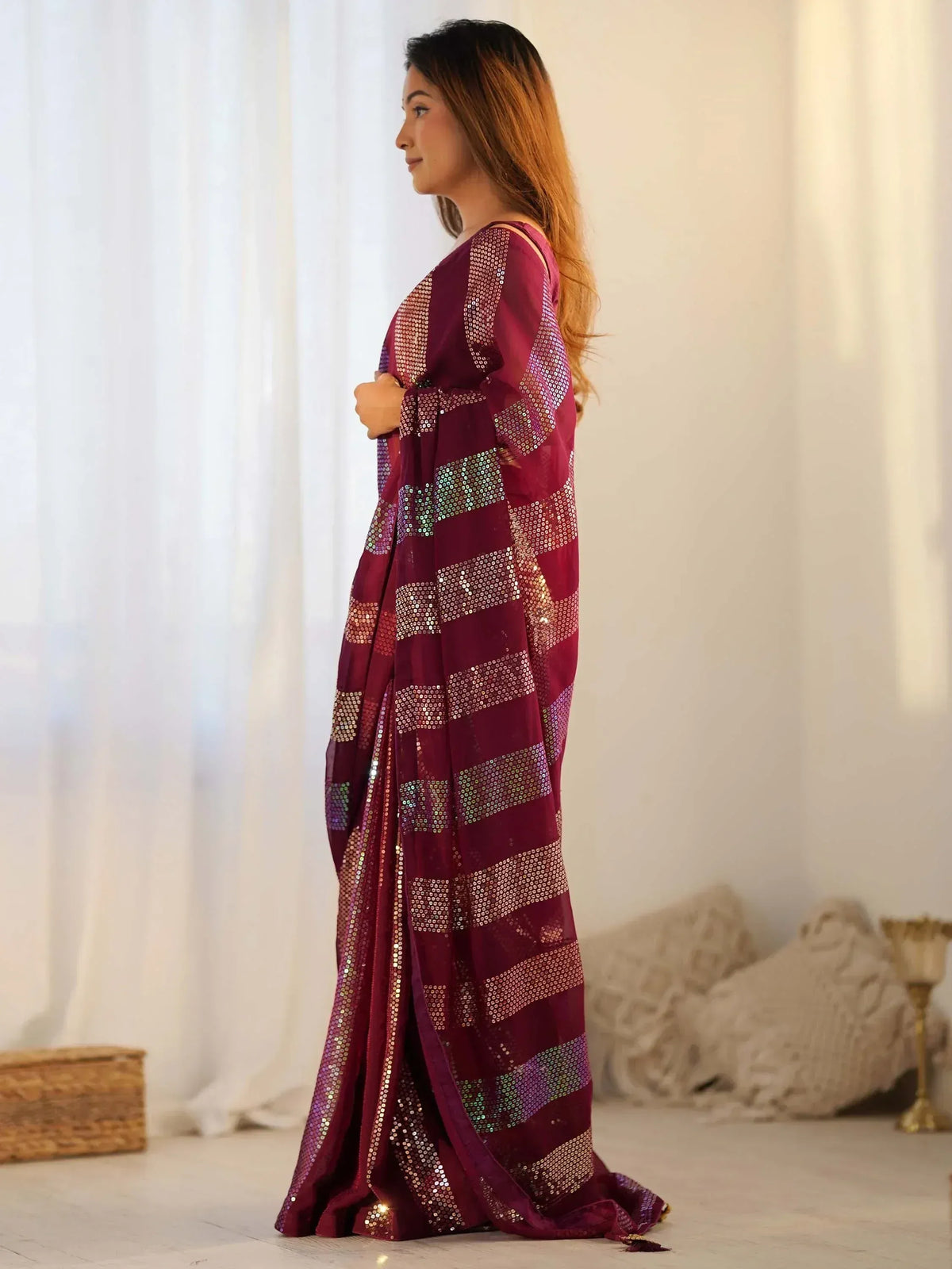 Woman in maroon sequin saree with striped pattern, elegant ethnic wear for festive occasions