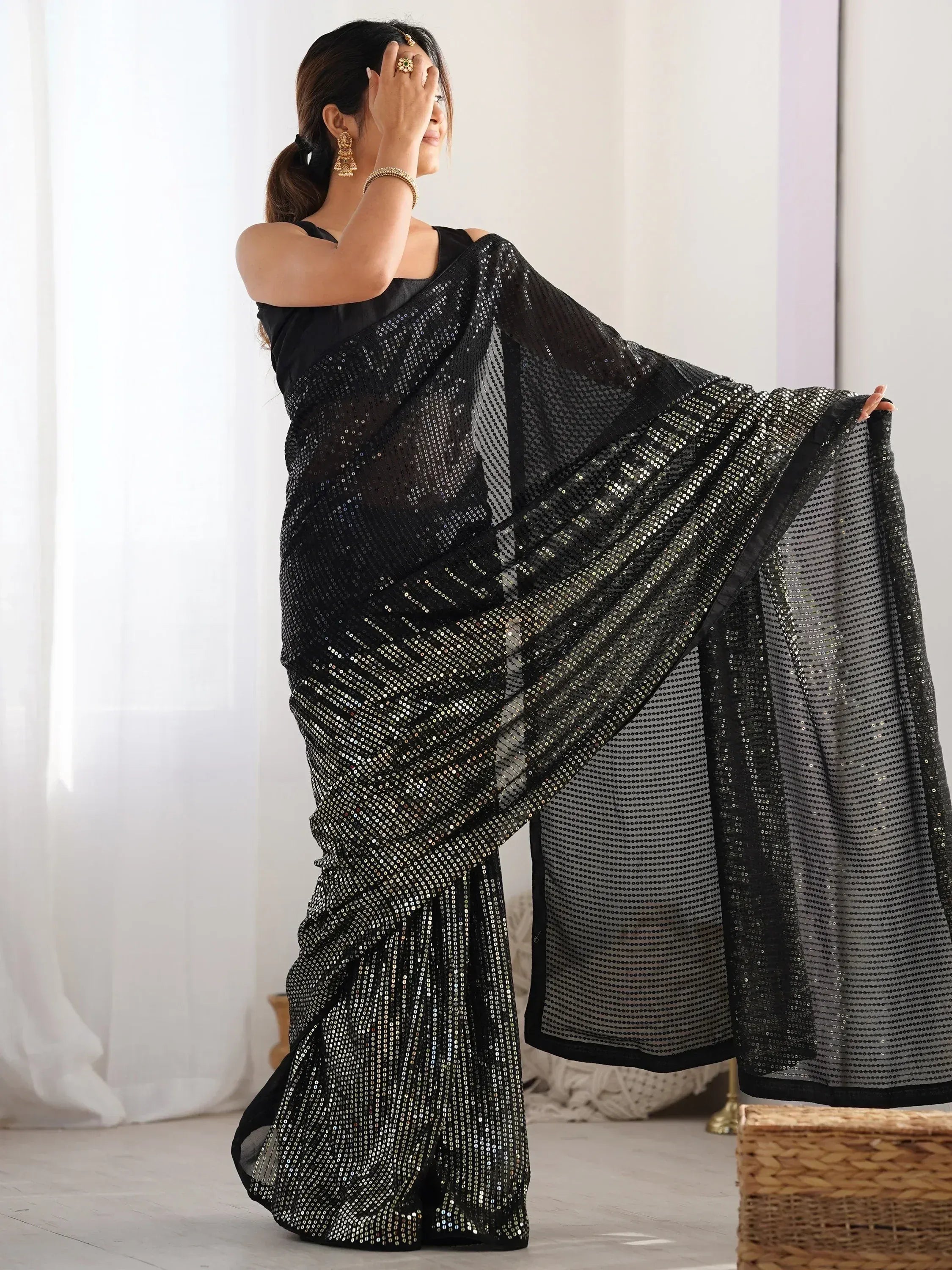 Black sequin saree with sheer pallu, styled with gold jewelry for ethnic wear