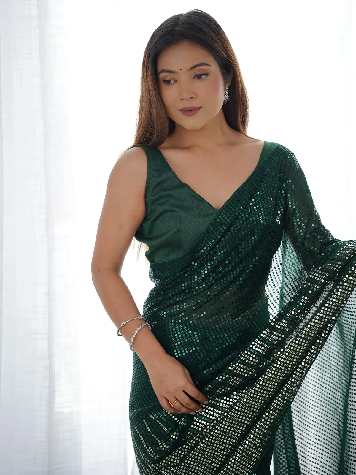 Woman in elegant green sequin saree with V-neck blouse, perfect for Indian ethnic occasions