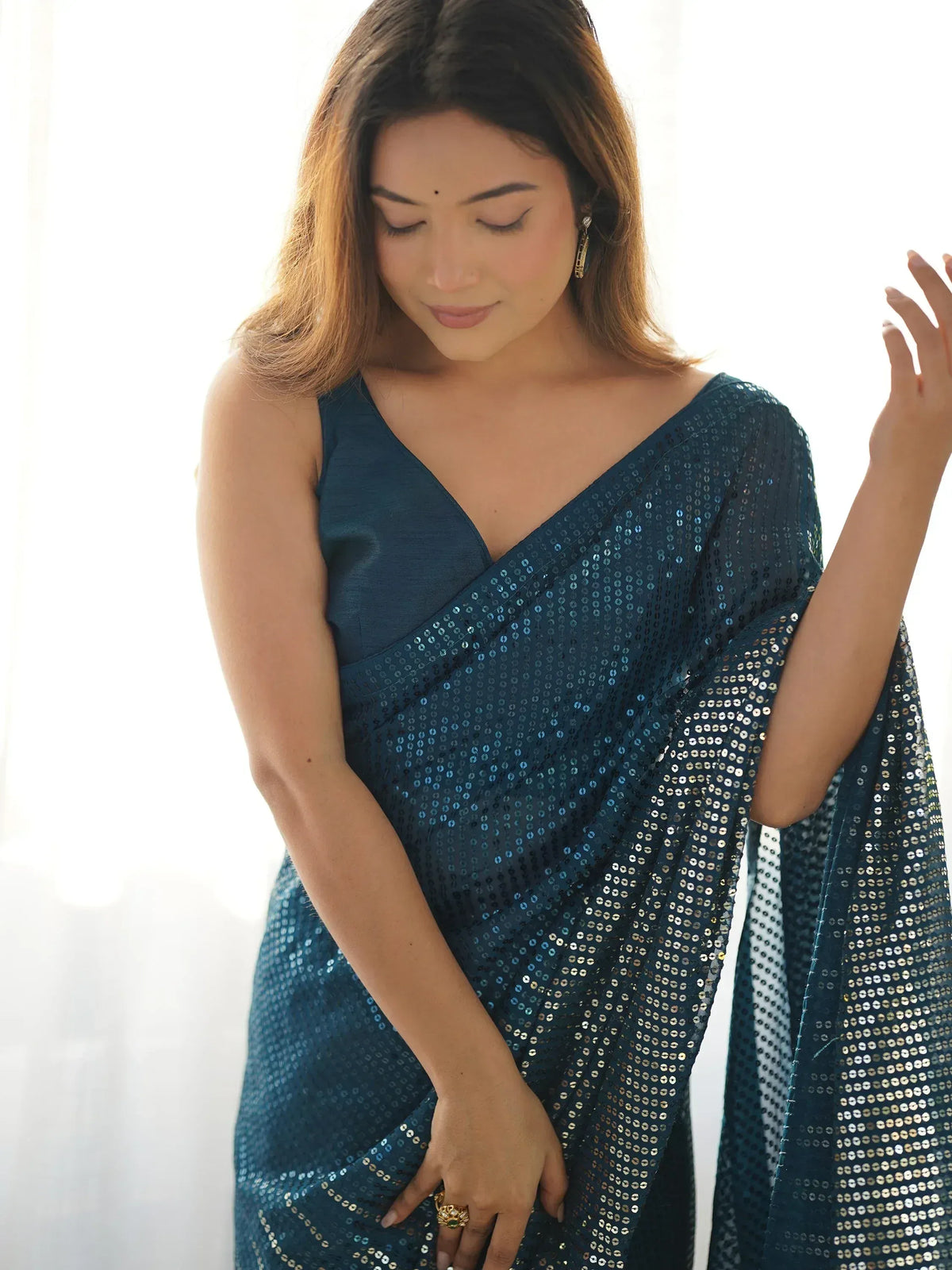 Woman in elegant teal sequin saree with V-neck blouse, perfect for Indian ethnic occasions