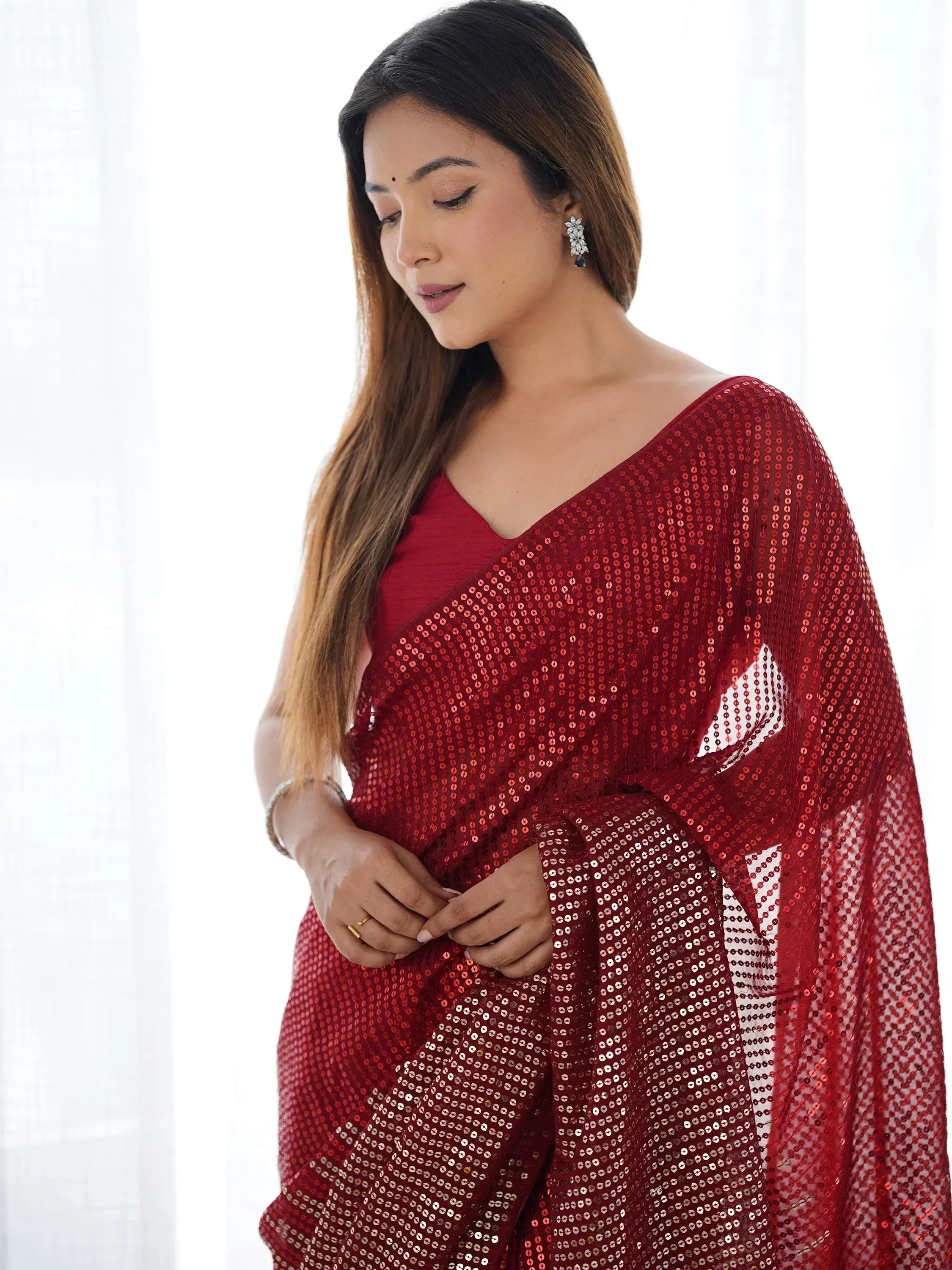 Woman in red sequin saree with V-neck blouse, elegant ethnic wear for festive occasions