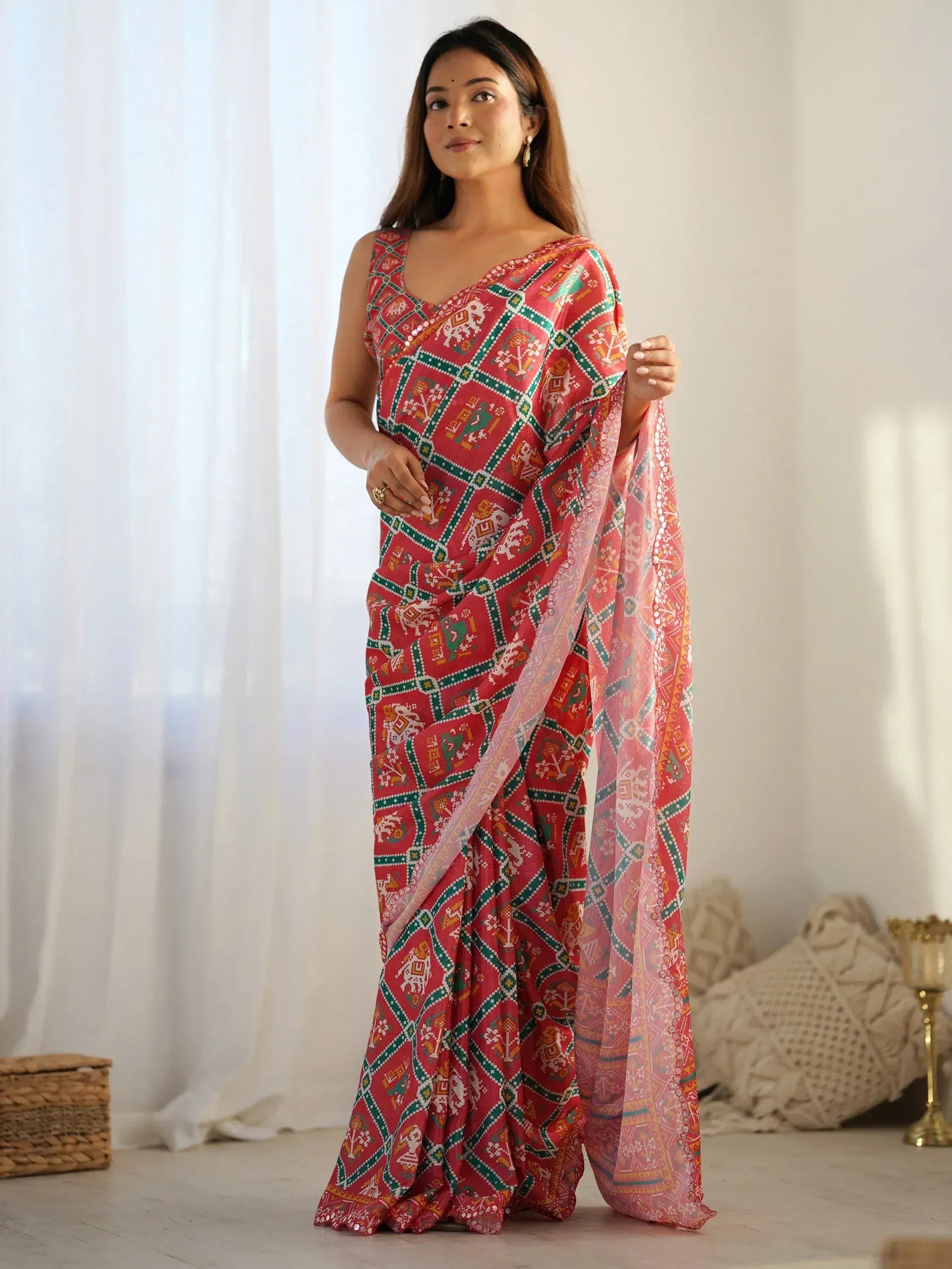 Woman in red and green printed ethnic saree with elephant motifs, stylish Indian wear for festive occasions