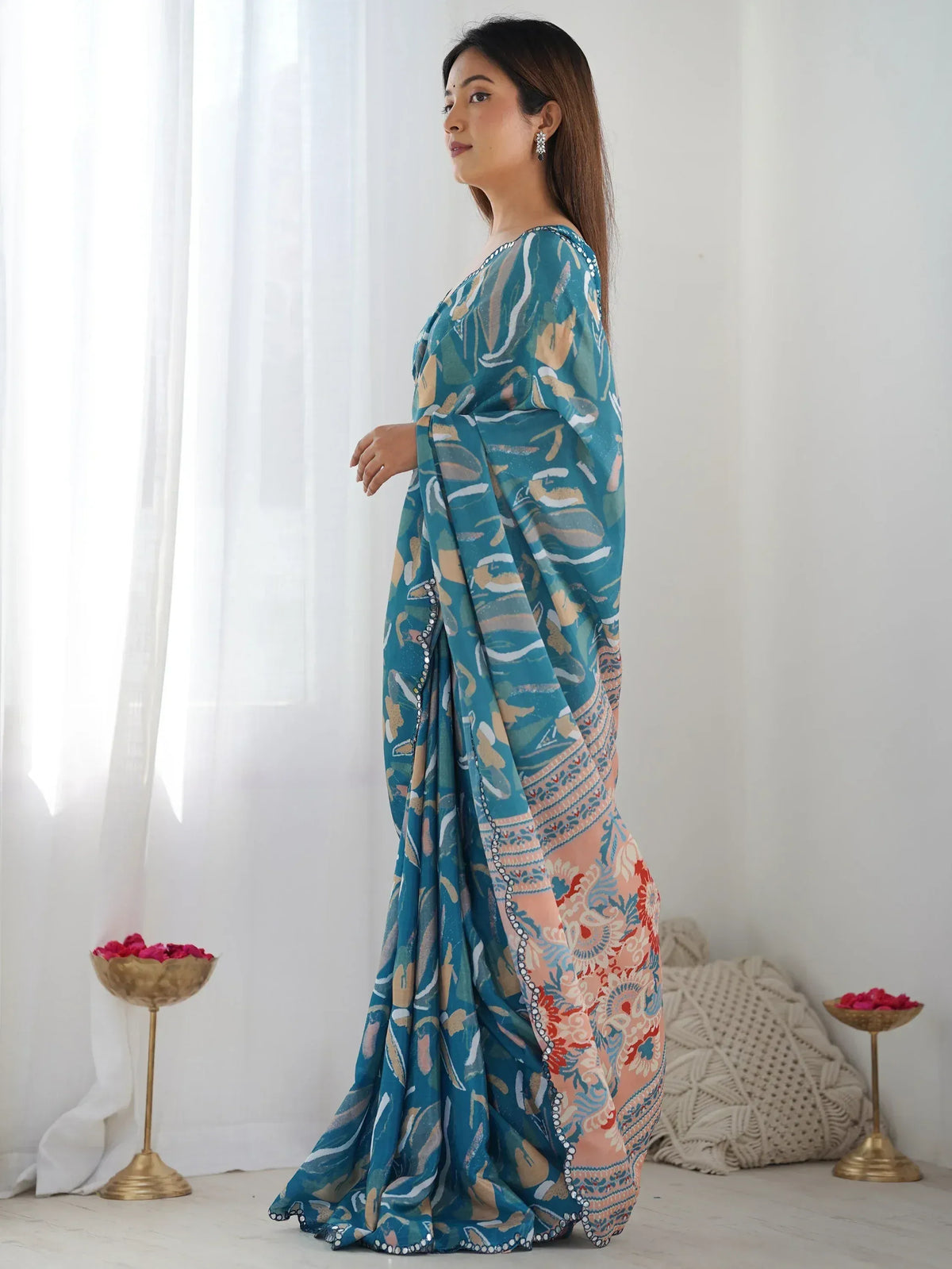 Teal printed saree with floral motifs and embellished border, styled for ethnic occasions