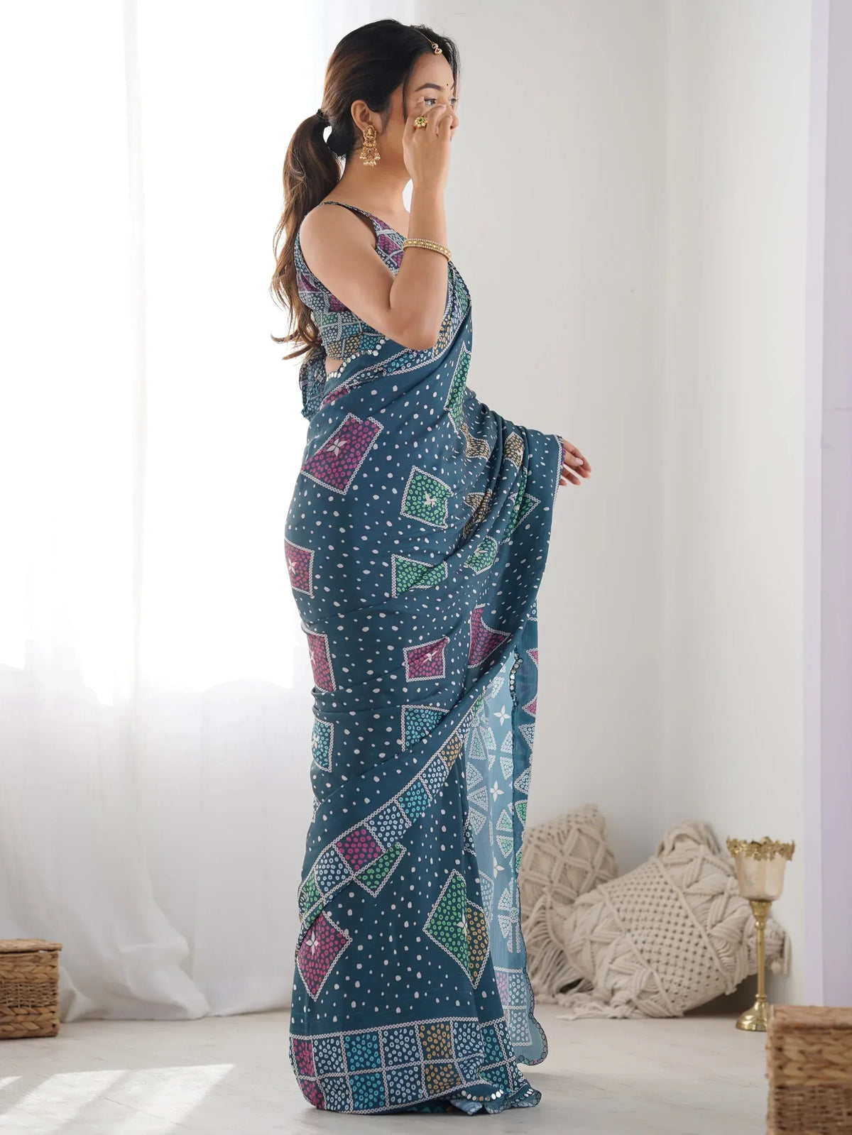 Woman in teal printed saree with geometric patterns, ethnic Indian wear, stylish designer look