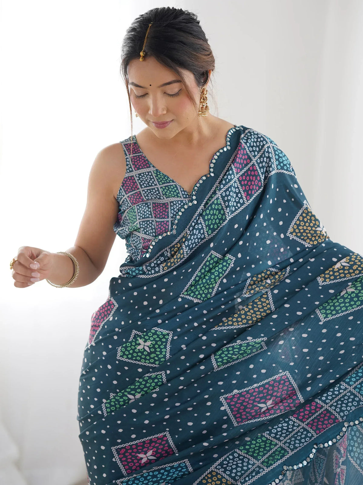 Woman in teal printed saree with mirror work, traditional Indian ethnic wear