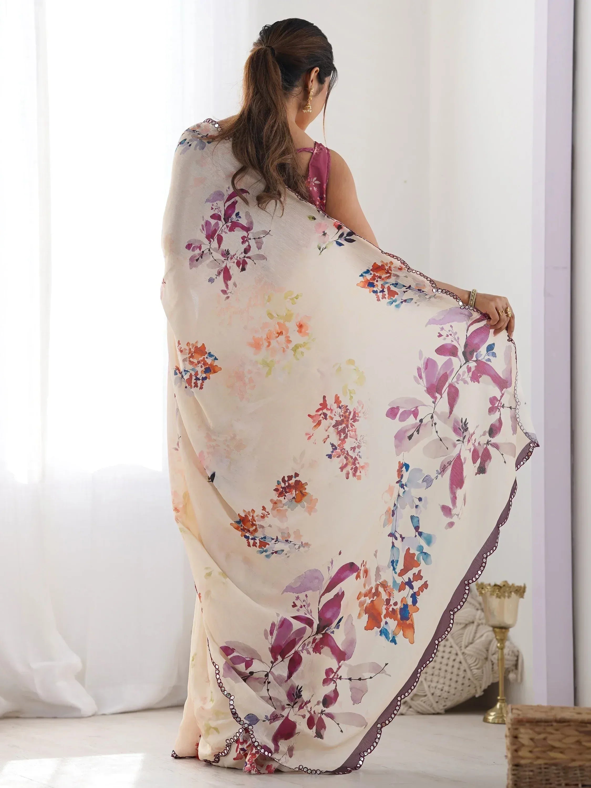Woman in floral print saree with mirror work border, ethnic Indian wear