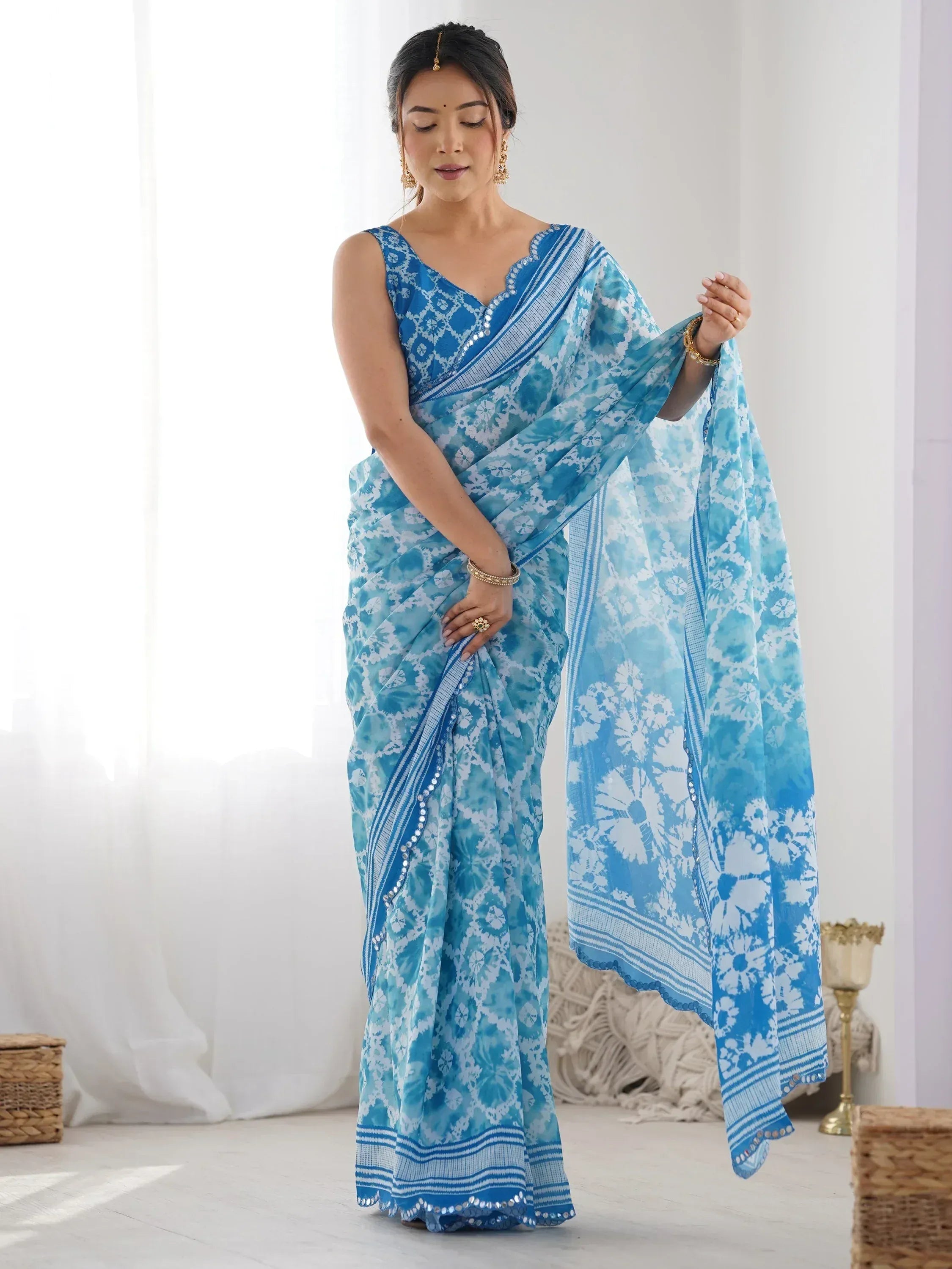 Blue and white floral print saree with sequin border, styled with ethnic jewelry for Indian occasions