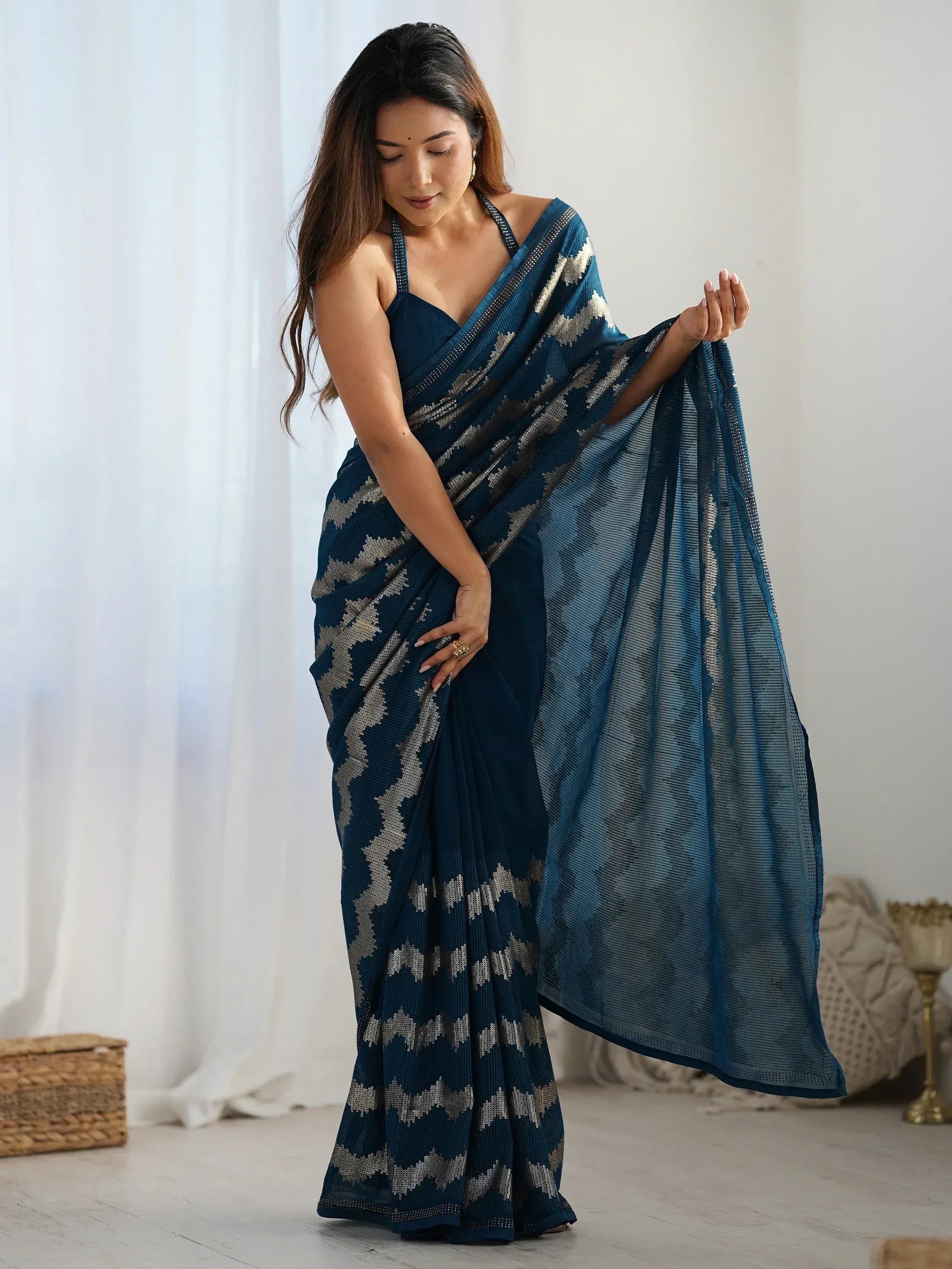 Woman in elegant navy blue saree with silver geometric print, styled with halter neck blouse for ethnic wear