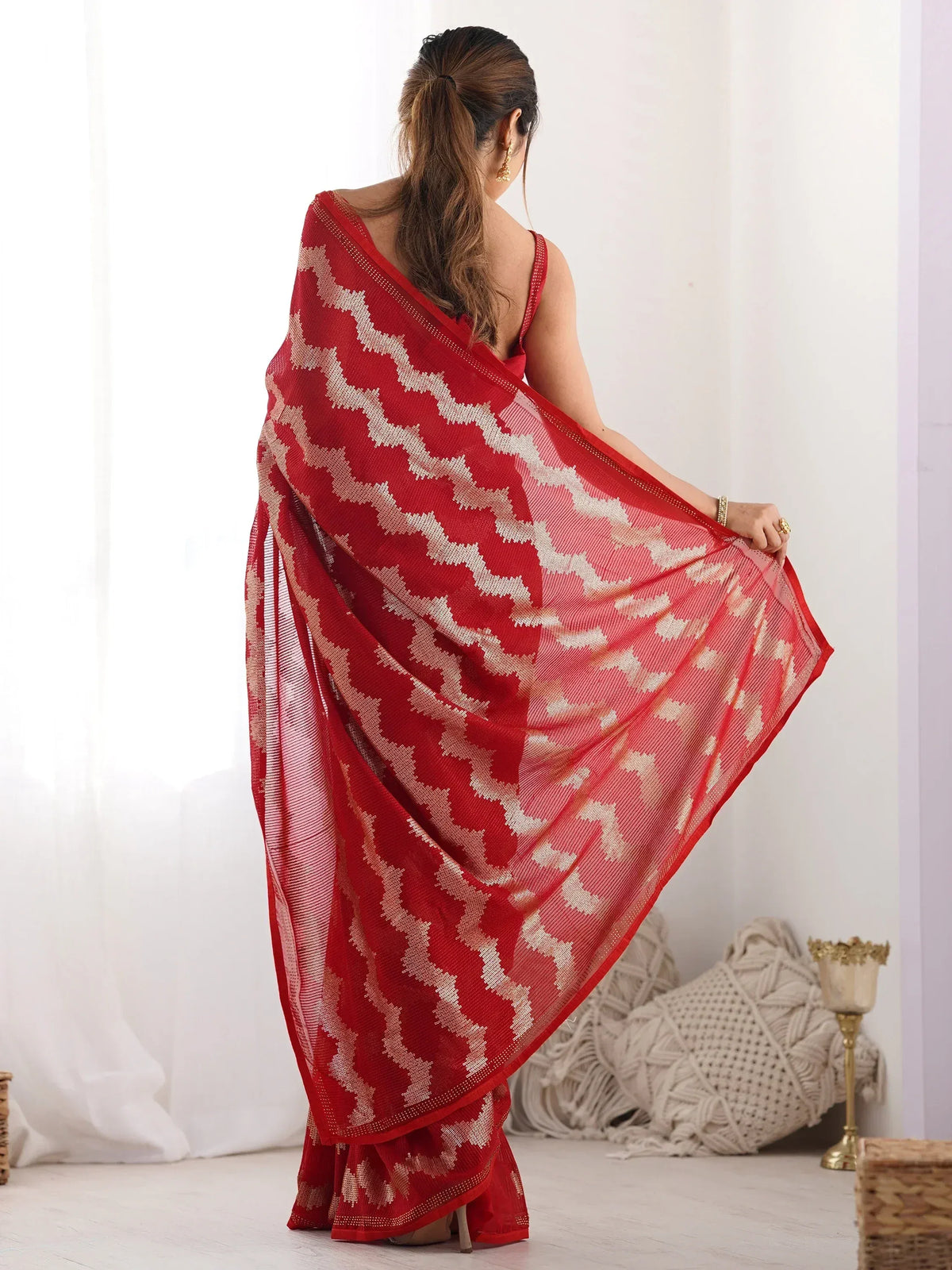 Red ethnic saree with white geometric pattern, styled with gold jewelry for traditional Indian wear