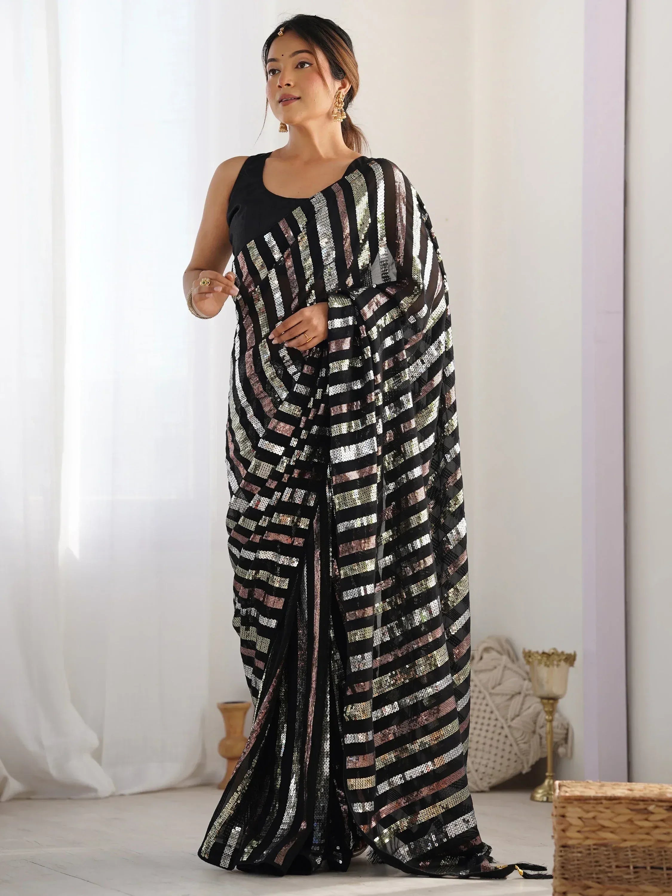 Woman in black sequin saree with striped pattern, ethnic Indian wear for festive occasions