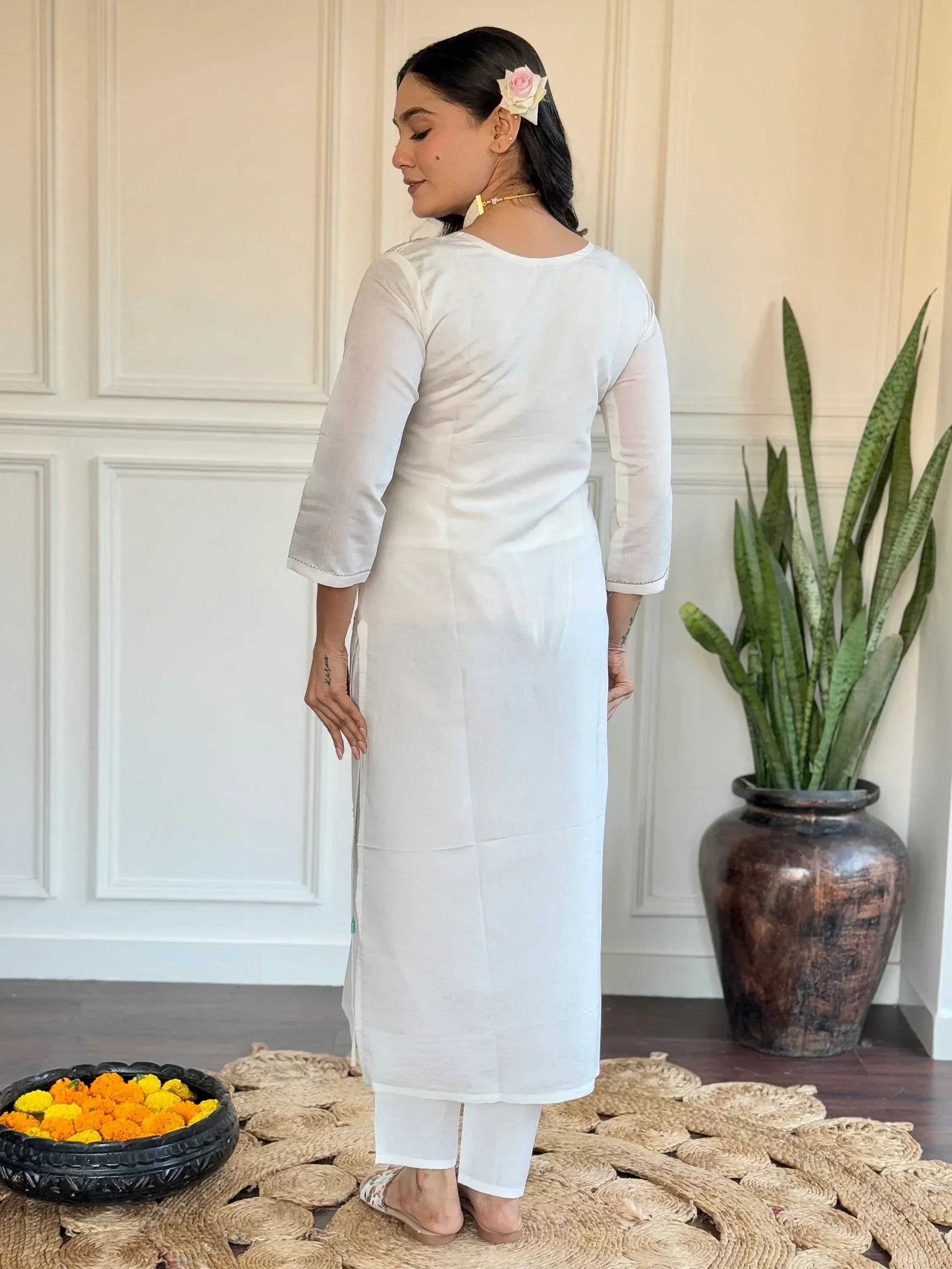 White cotton kurta with 3/4 sleeves and side slits, paired with matching pants, ideal for ethnic wear.