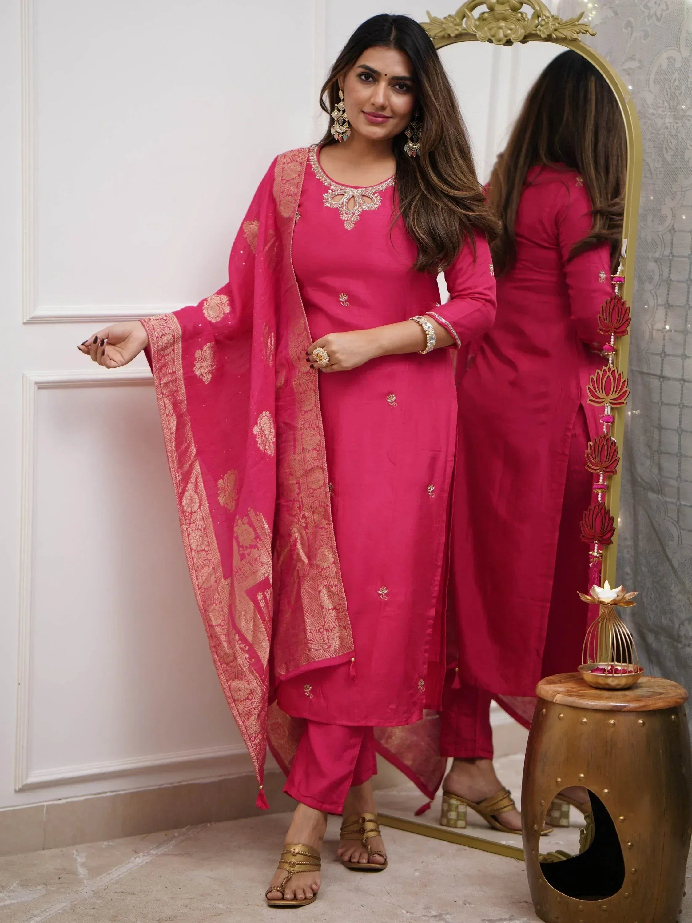 Pink Indian ethnic salwar kameez with gold embroidery, paired with matching dupatta and statement jewelry.