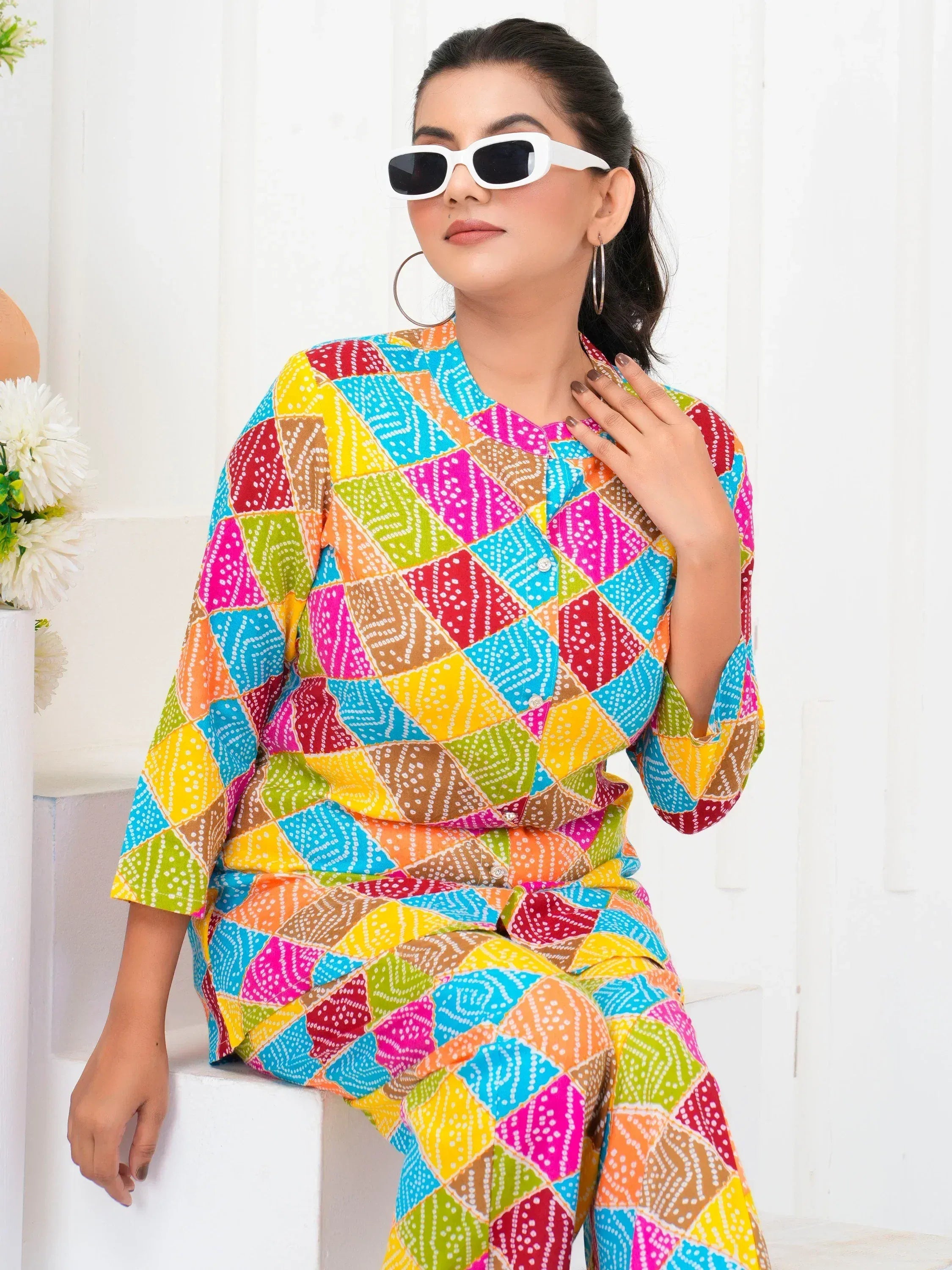 Vibrant multicolor ethnic salwar kameez with geometric print, stylish sunglasses, and hoop earrings