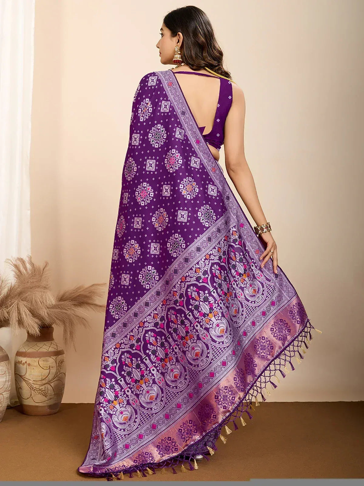 Purple printed saree with intricate paisley and geometric patterns, tassel border, paired with backless blouse