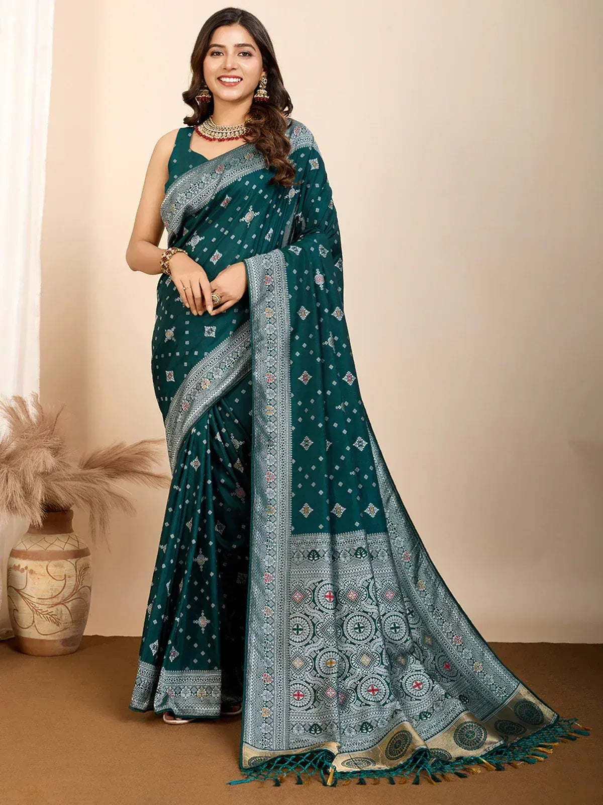 Emerald green printed saree with silver border and tassels, styled with ethnic jewelry for festive occasions