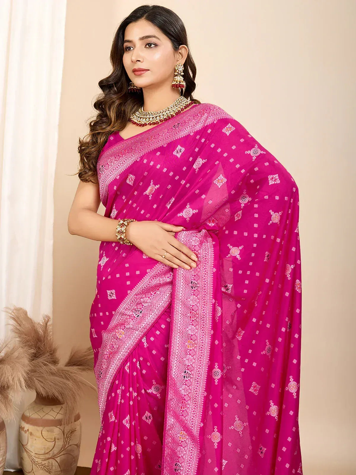 Vibrant pink printed saree with intricate embroidery and traditional jewelry
