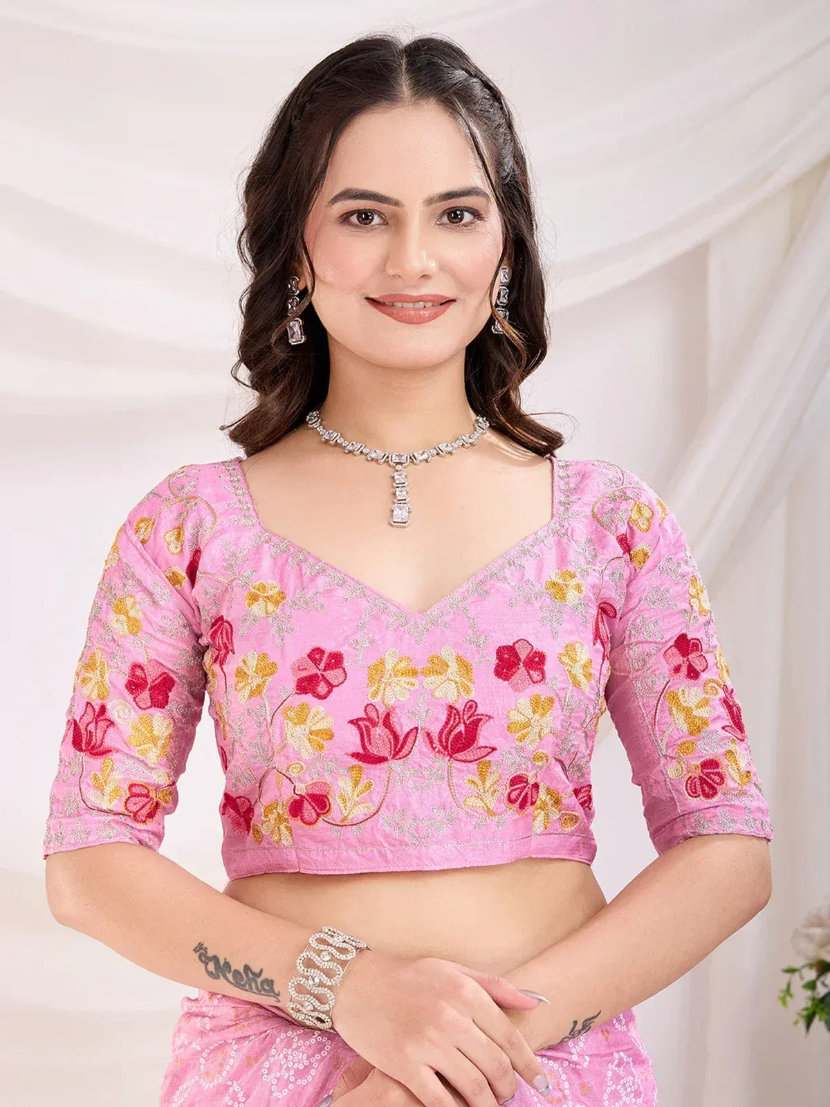 Pink floral embroidered lehenga choli top with V-neck and 3/4 sleeves, styled with jewelry