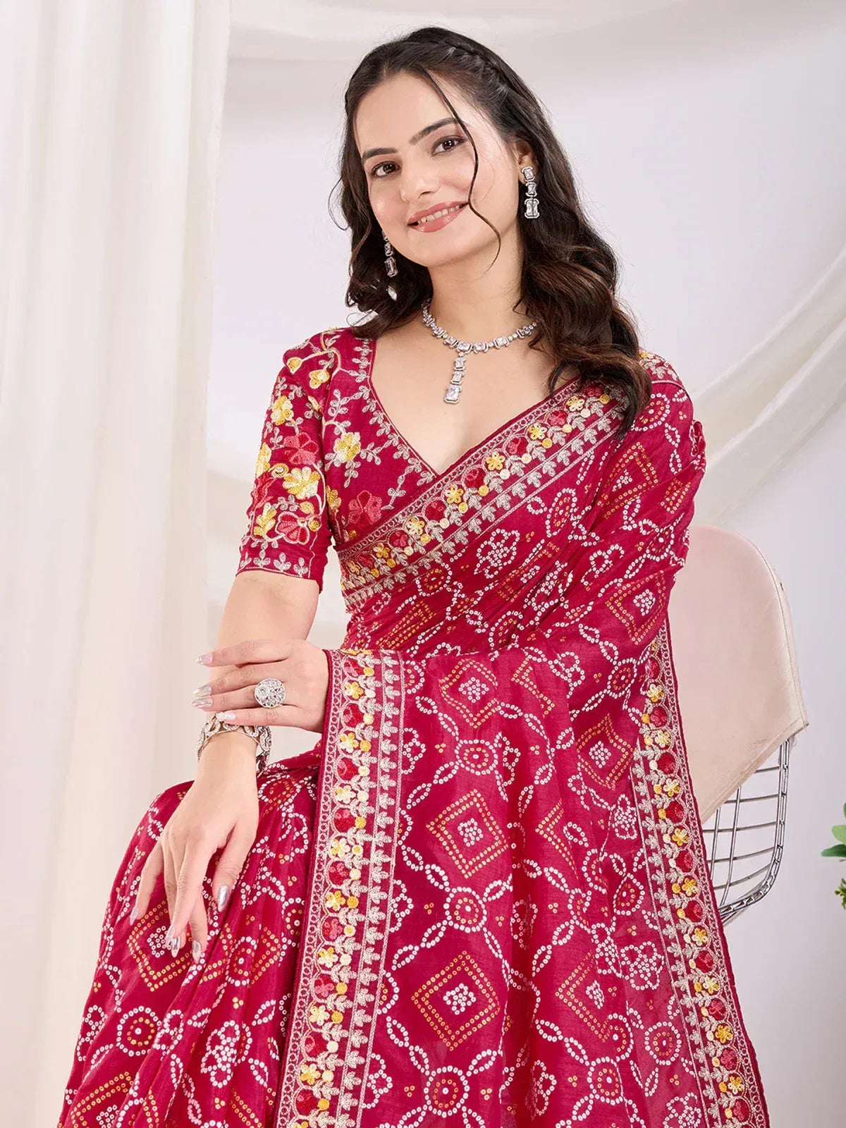 Woman in red embroidered Indian ethnic gown with floral and geometric patterns, styled with jewelry