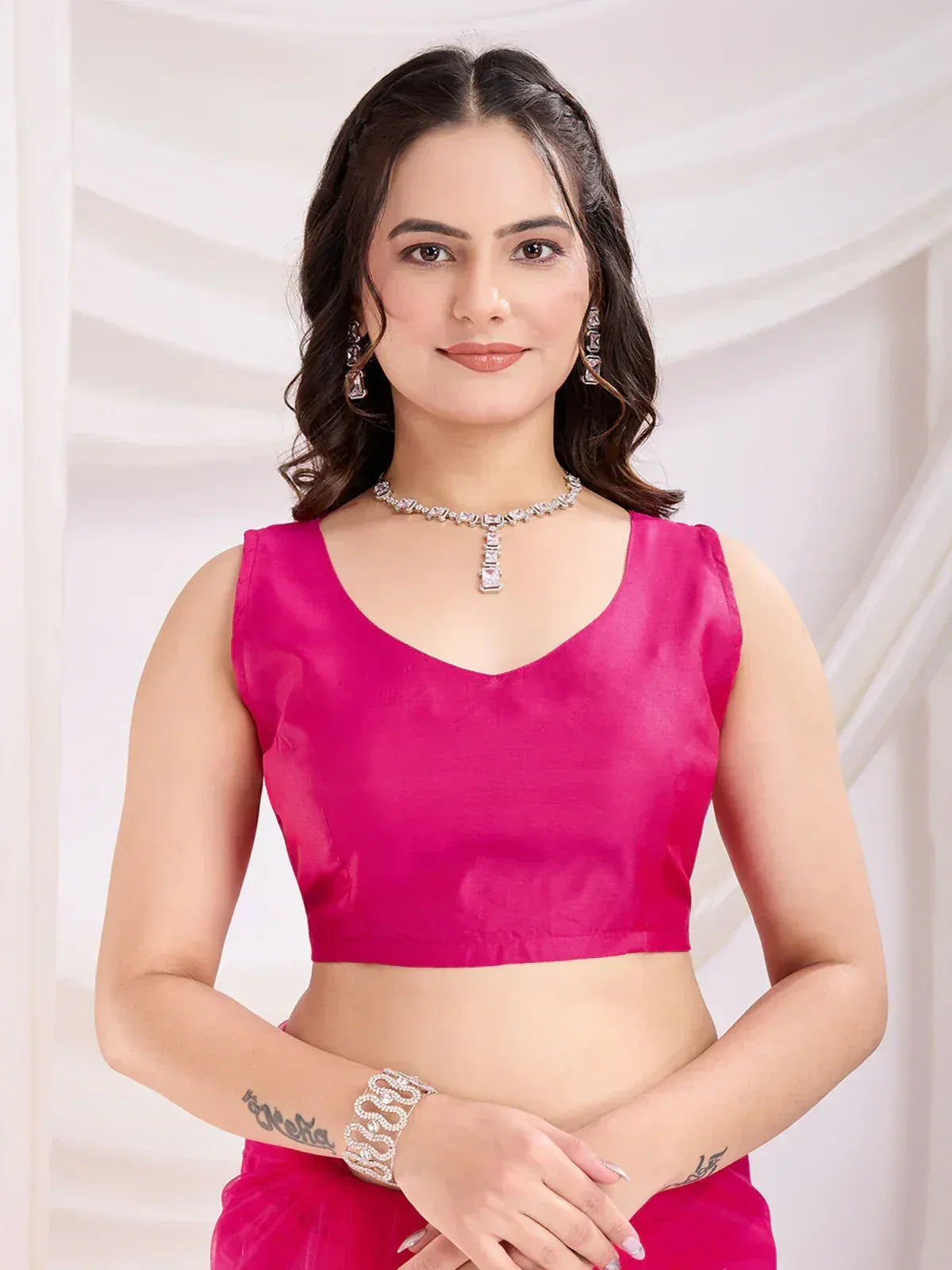 Fuchsia sleeveless blouse with V-neck, paired with matching skirt, styled with diamond jewelry for Indian ethnic wear