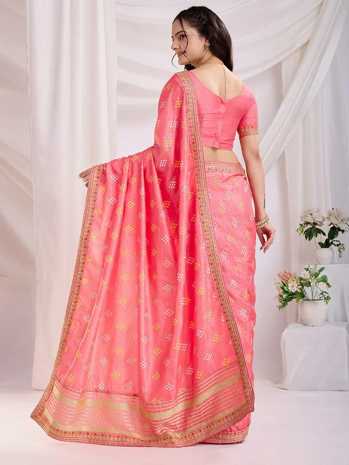 Pink ethnic saree with gold border and geometric print, paired with matching blouse for traditional Indian wear