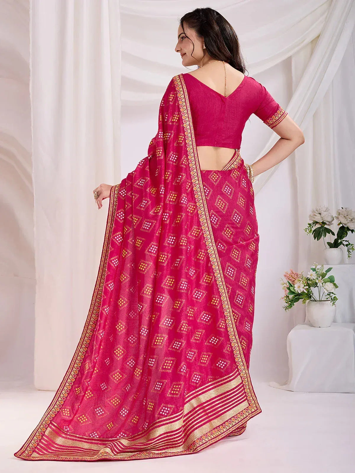 Pink ethnic saree with geometric print and gold border, paired with matching blouse for Indian wear
