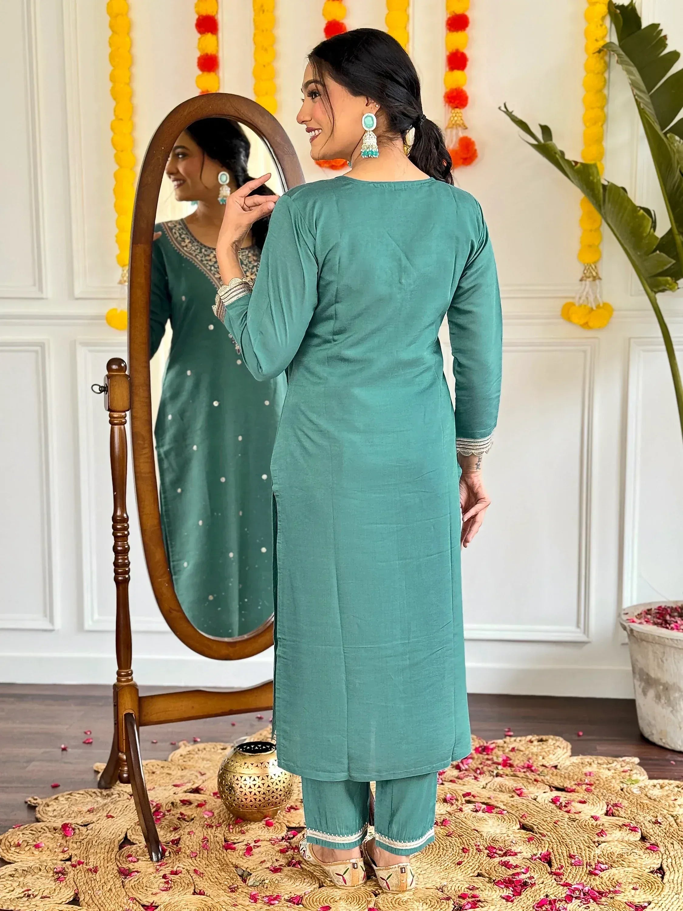 Teal ethnic kurti with white embroidery, paired with matching pants, styled with statement earrings and mirror reflection.