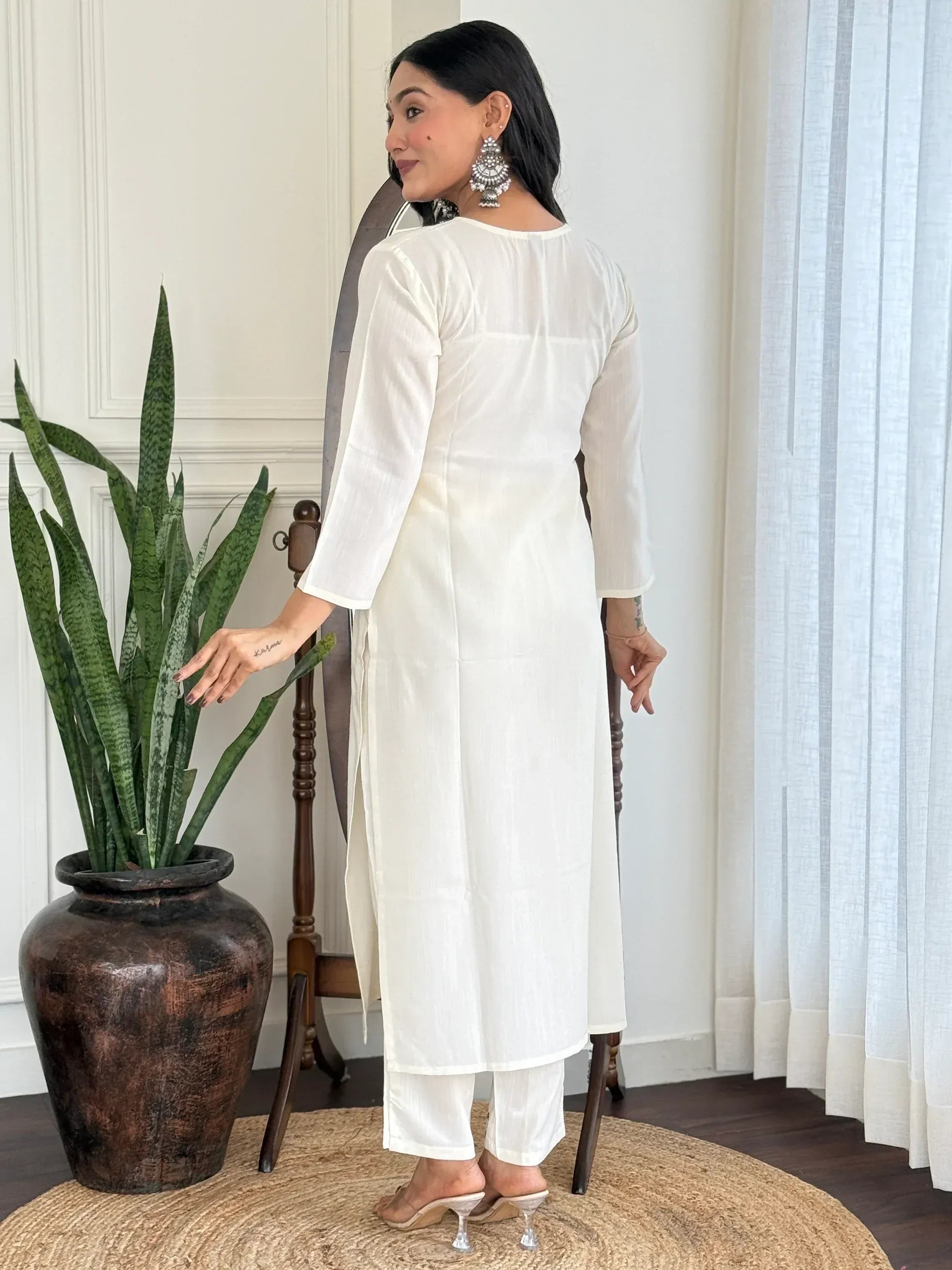 White ethnic kurta with side slits paired with matching pants, styled with statement earrings for Indian wear