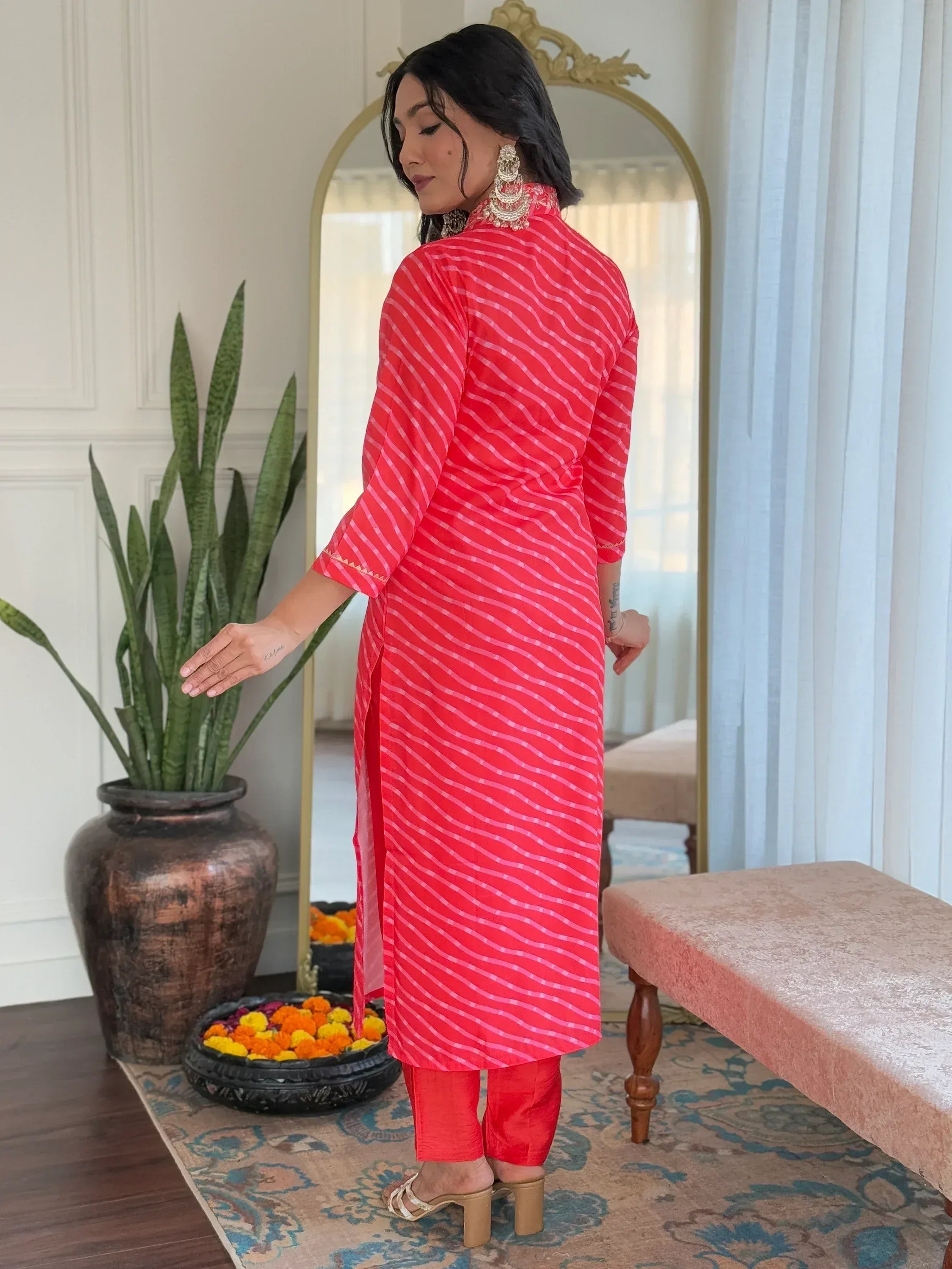 Woman in red striped ethnic kurta with matching pants, traditional Indian wear for festive occasions