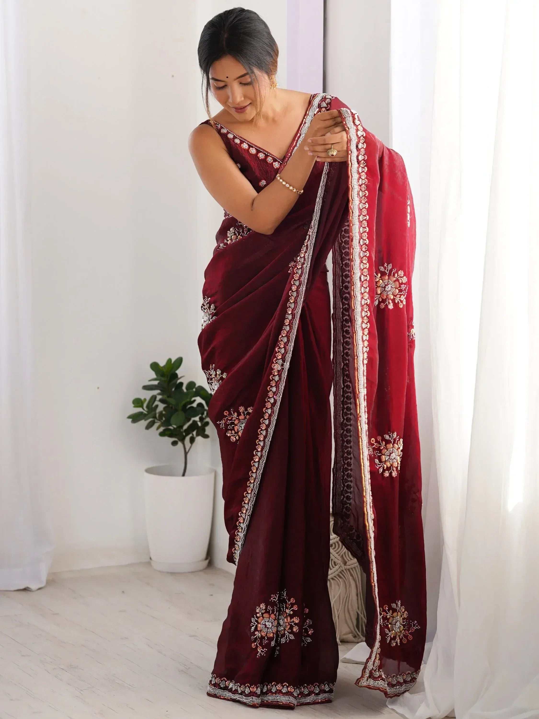 Woman in maroon velvet saree with floral embroidery and beaded border, Indian ethnic wear