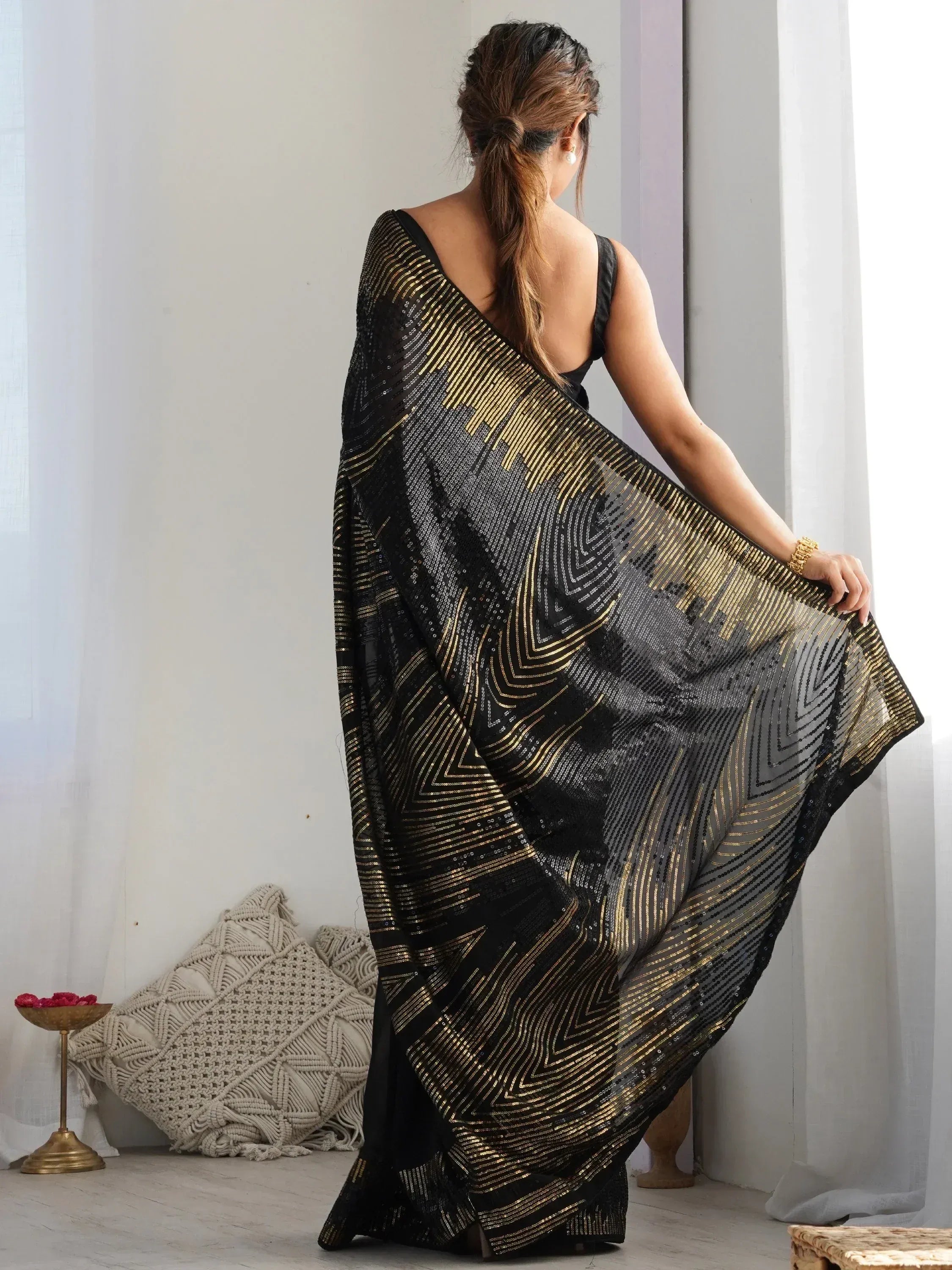 Black and gold sequin saree with geometric pattern, styled for ethnic wear