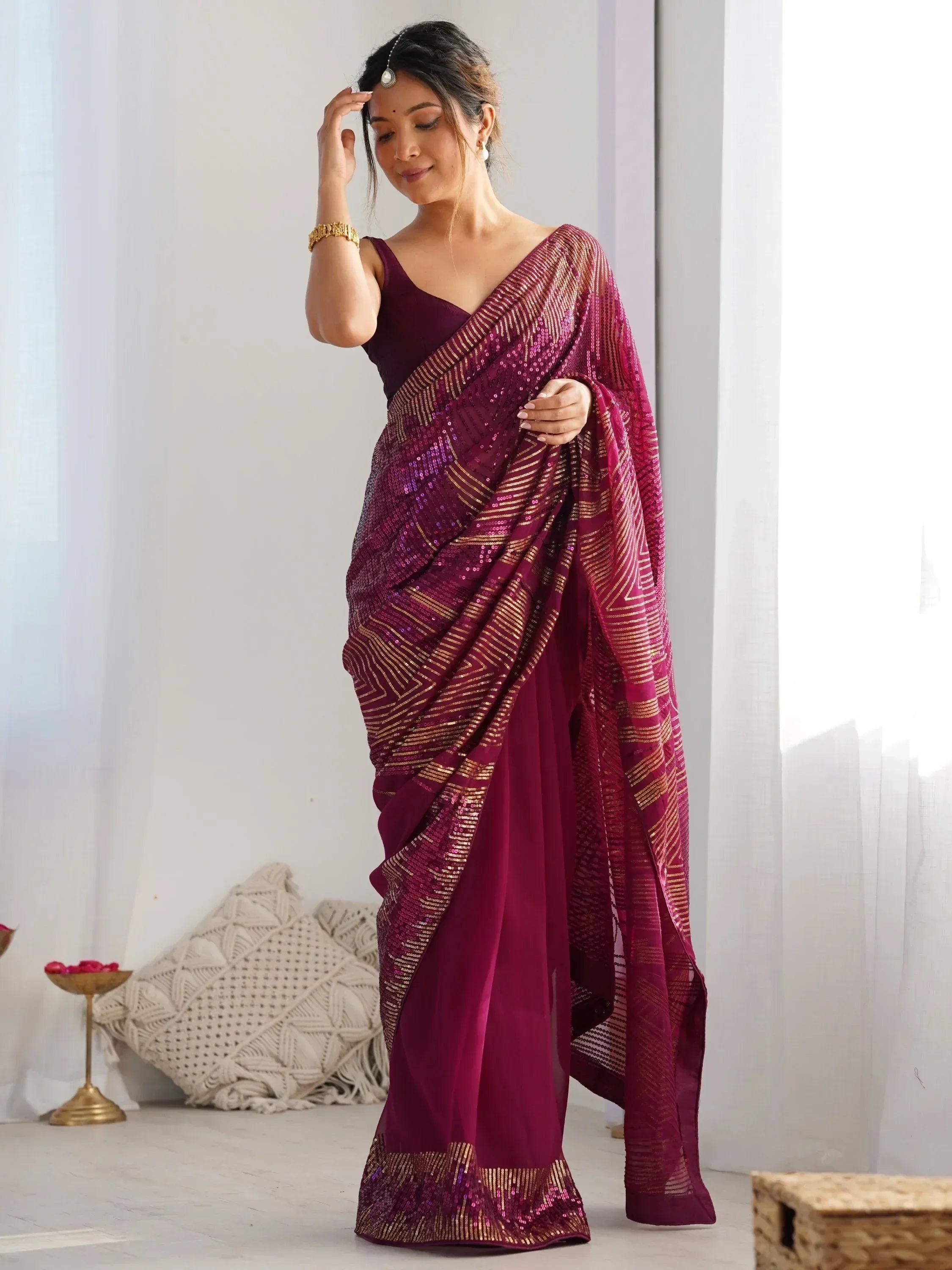 Woman in maroon sequin saree with gold stripes, Indian ethnic wear for festive occasions