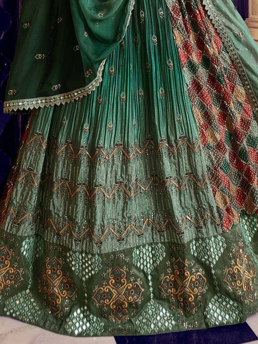Emerald green designer lehenga with intricate gold embroidery and pleated skirt, perfect for Indian ethnic wear.