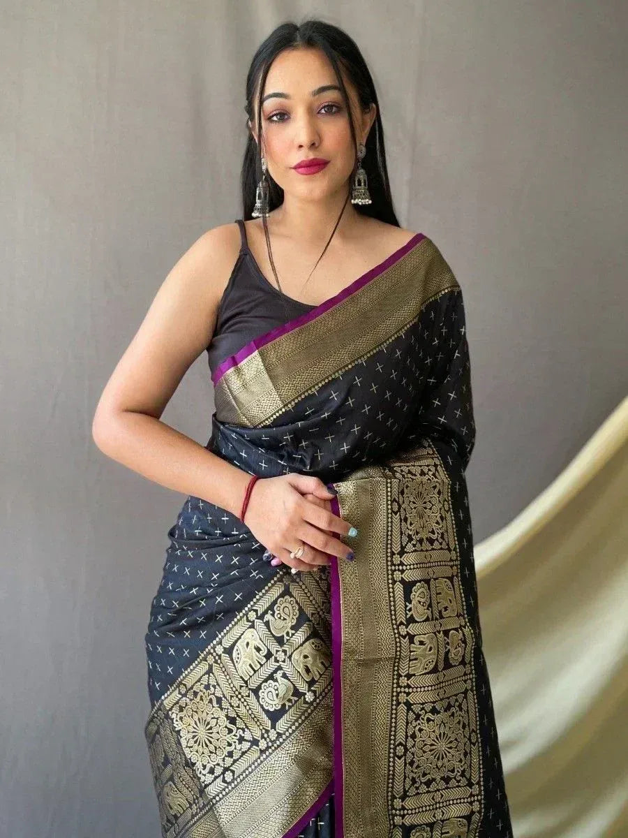 Black and gold ethnic saree with elephant motifs and purple border, styled with spaghetti blouse