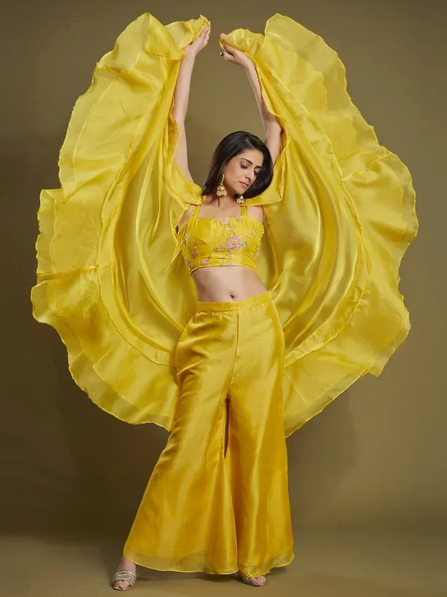 Woman in a bright yellow embroidered ethnic crop top with matching palazzo pants and draped dupatta