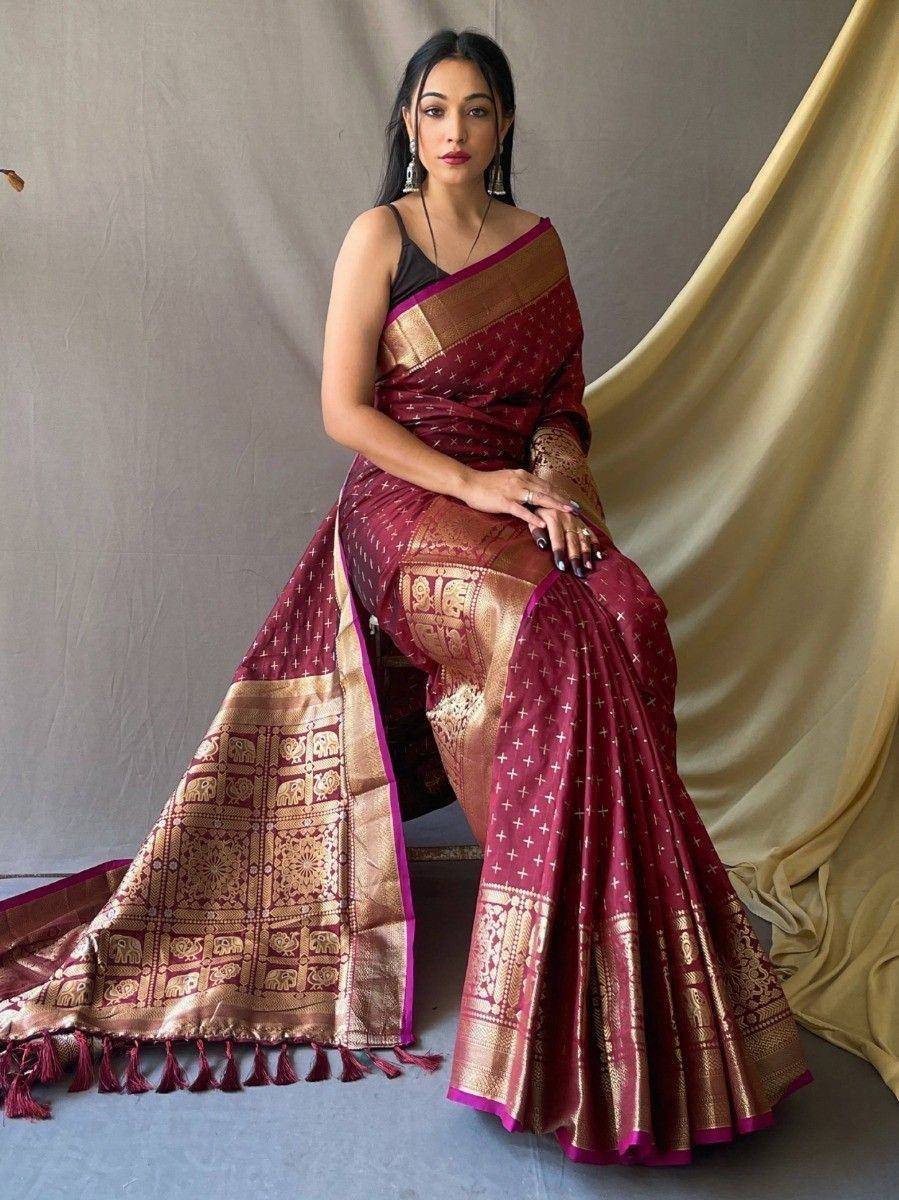 Maroon silk saree with gold elephant motifs and tassels, styled with black blouse for ethnic occasions