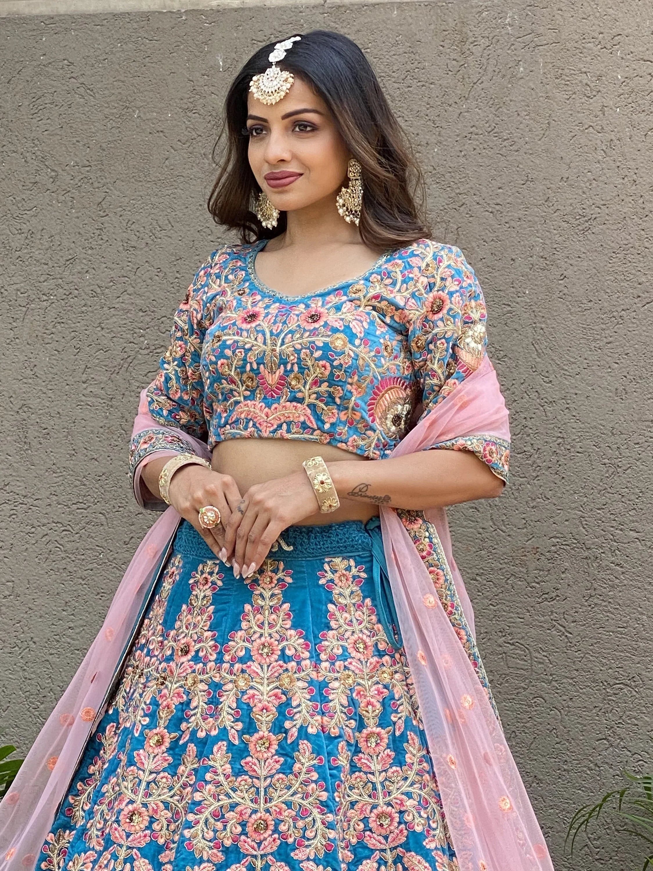 Blue floral embroidered lehenga choli with pink dupatta, perfect for Indian weddings and festive occasions.