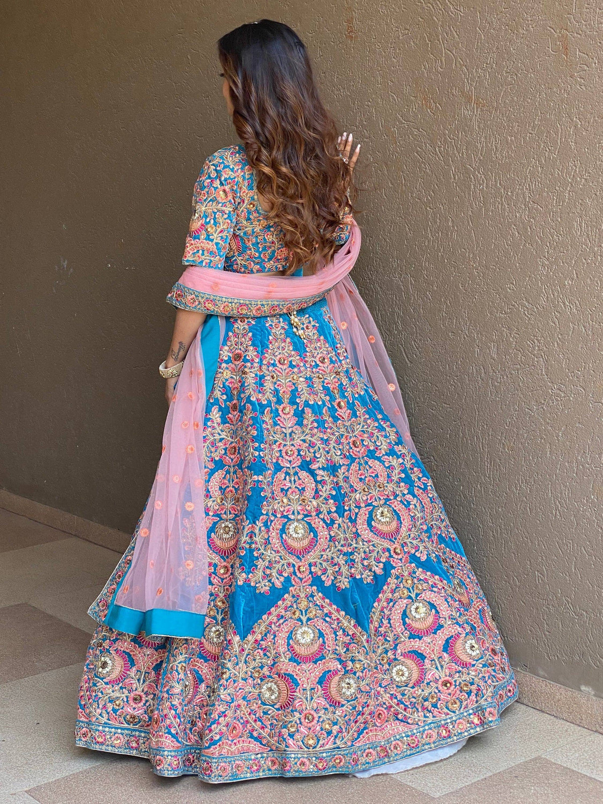 Blue and pink embroidered lehenga choli with floral motifs, perfect for Indian weddings and festive occasions.