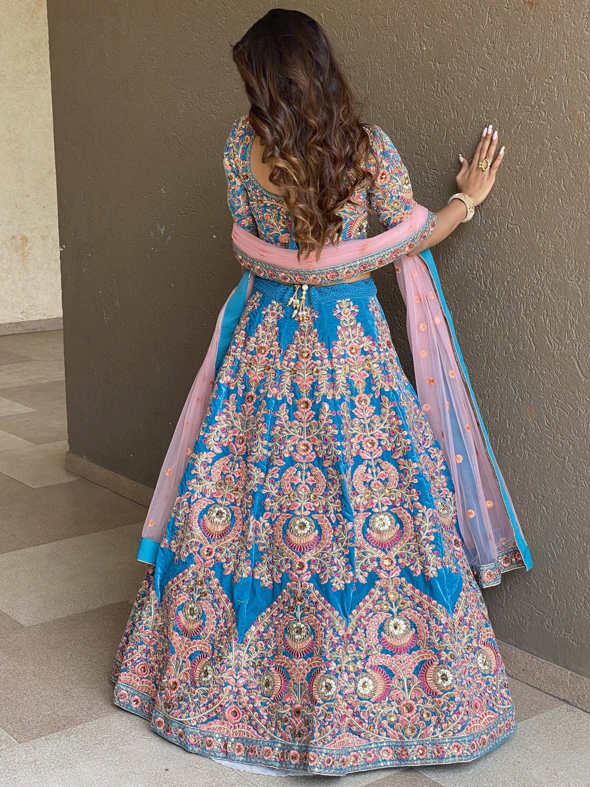 Blue and pink embroidered lehenga choli with floral motifs, perfect for Indian weddings and festive occasions.