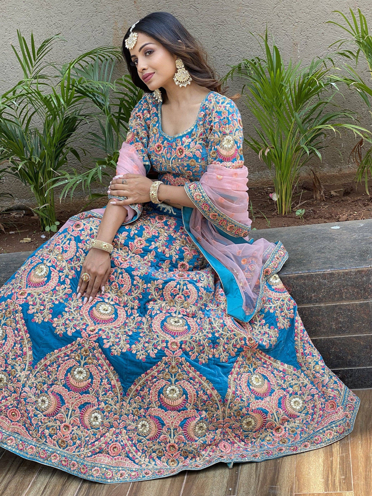 Blue and pink embroidered lehenga choli with floral motifs, perfect for Indian weddings and festive occasions.